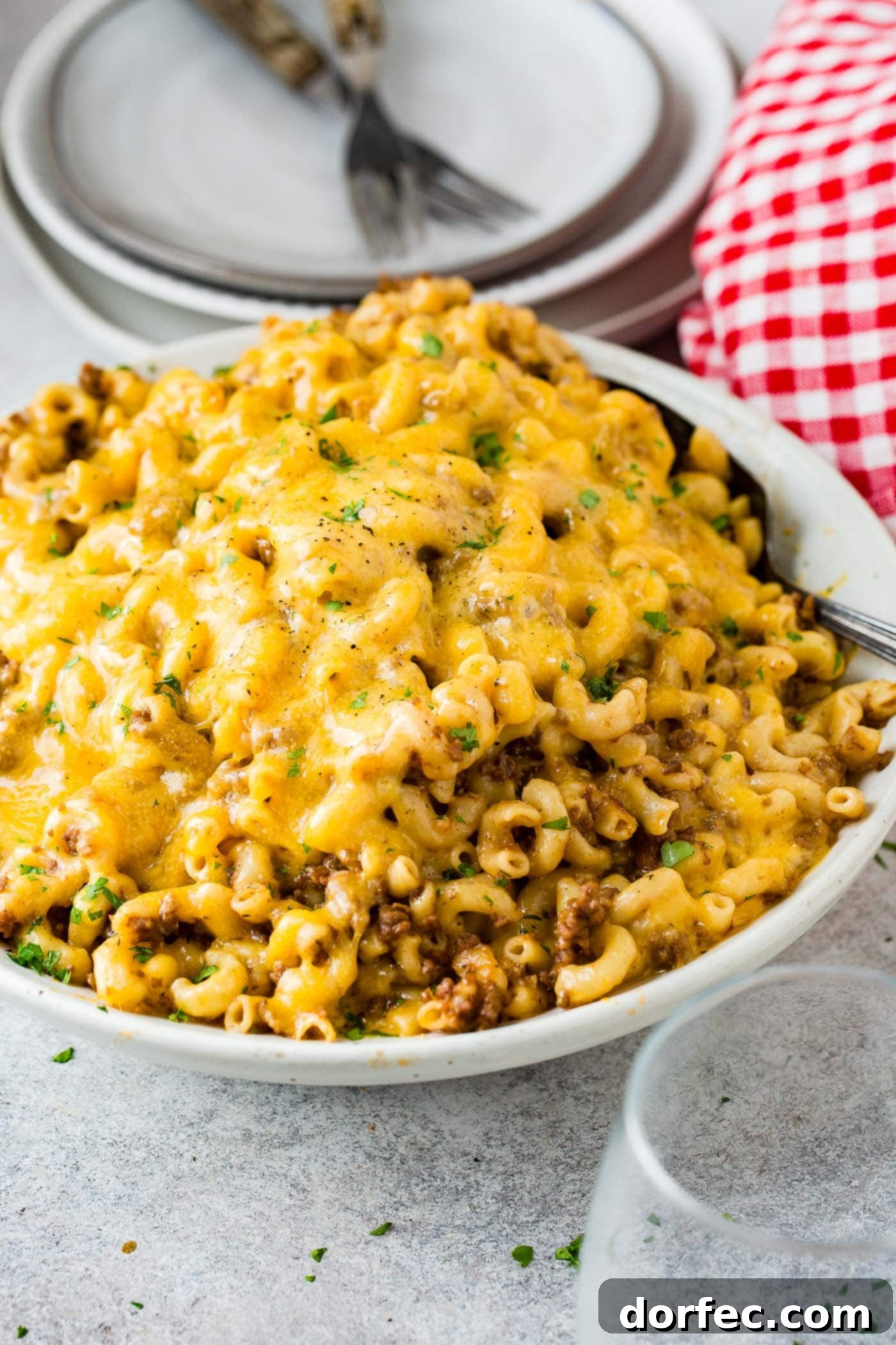 A photo of a white serving bowl full of cheesy Hamburger Helper ready to serve.