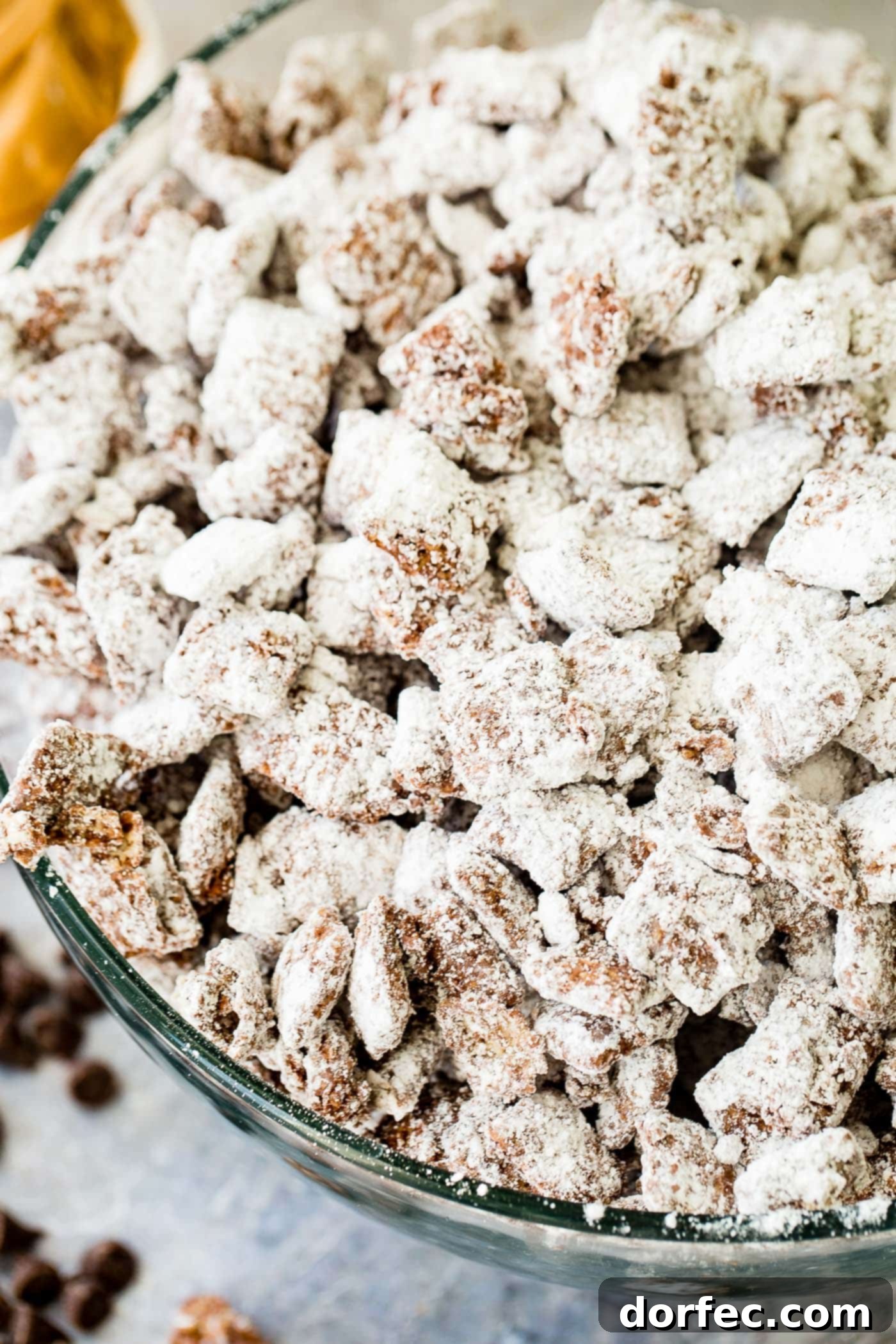 A photo of muddy buddies snack mix in a glass bowl.