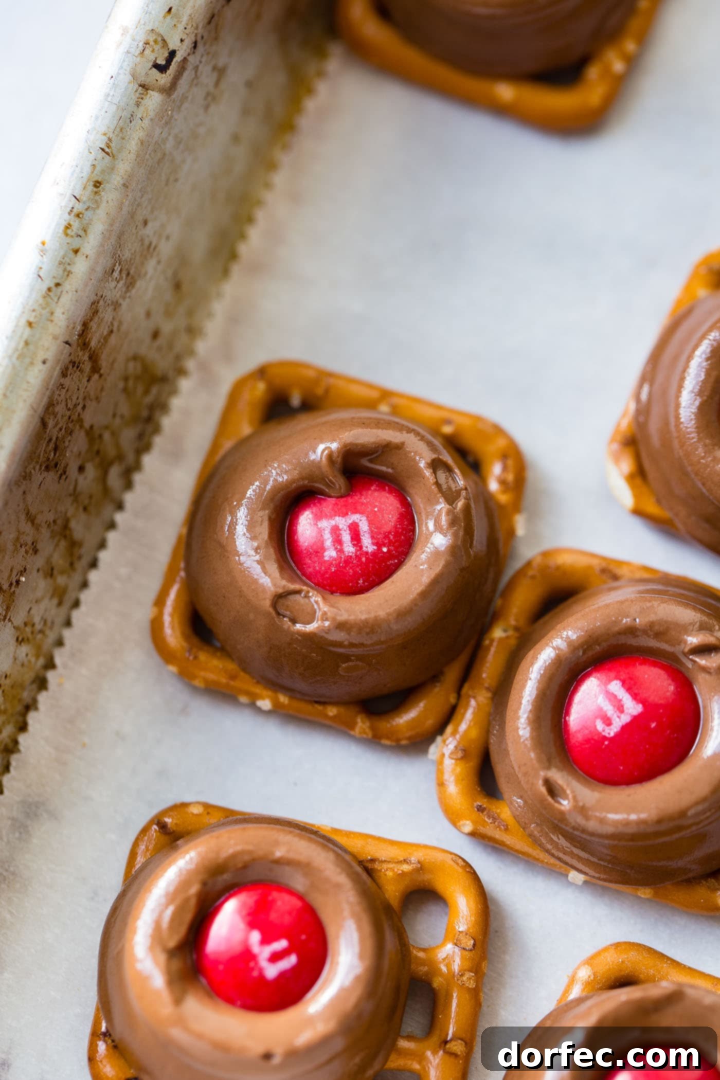 A beautifully arranged platter of Rolo pretzels, generously topped with festive red and green M&Ms, ready to be enjoyed.