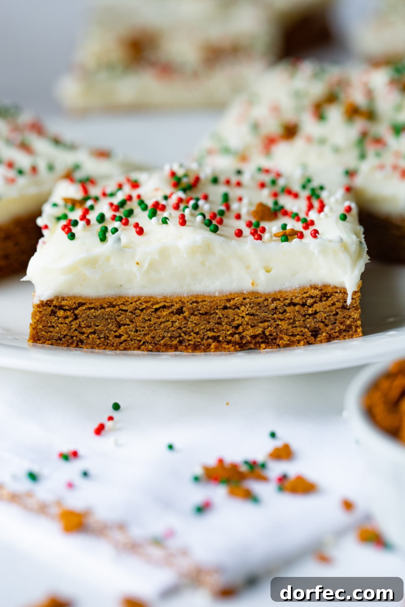 A photo of a single frosted gingerbread bar on a white plate.