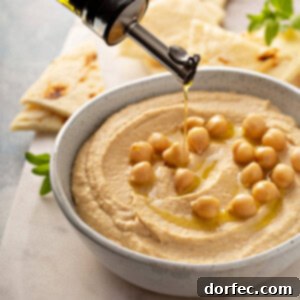 A bowl of fresh homemade hummus garnished with olive oil and paprika.