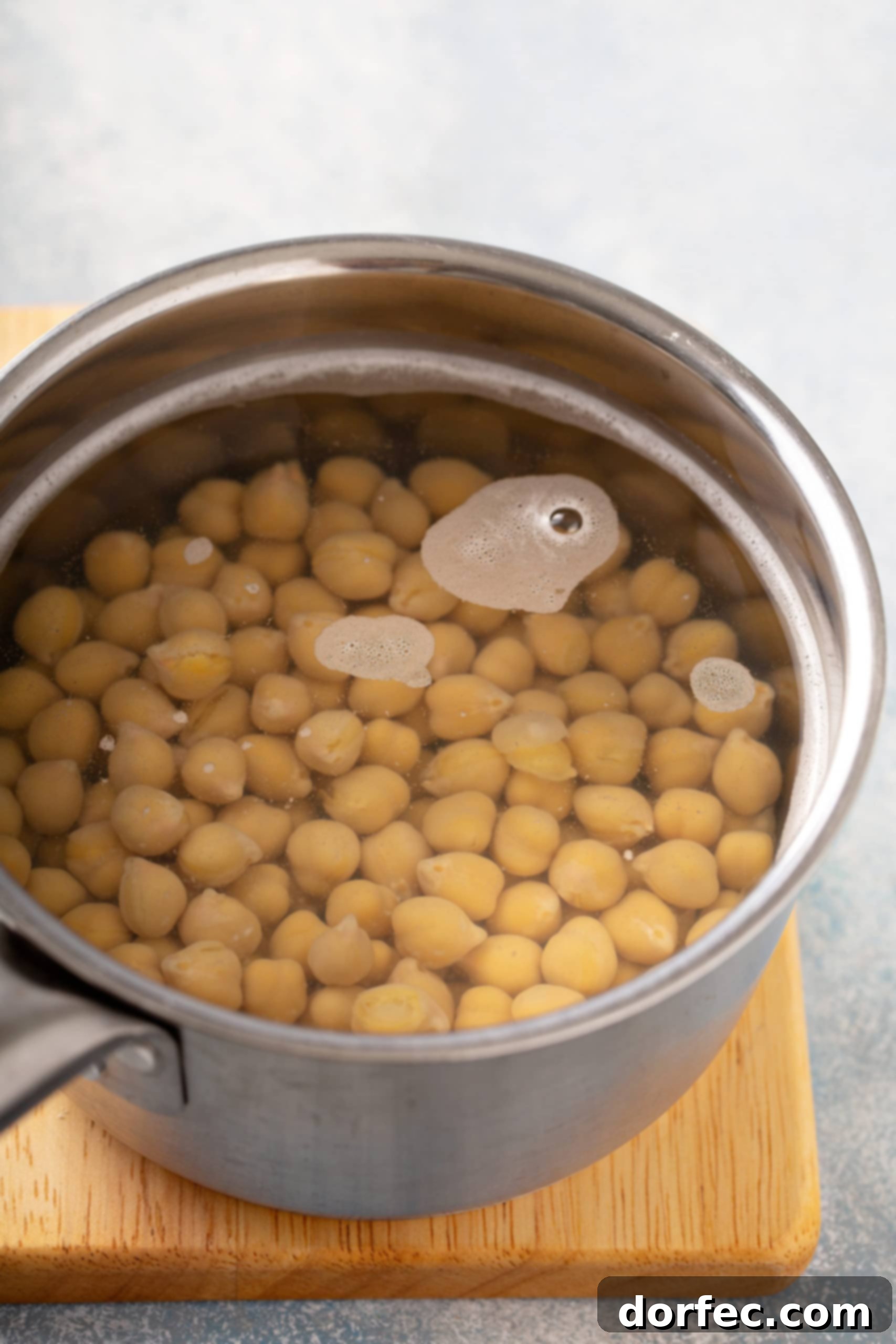 Best Easy Homemade Hummus A pan with chick peas covered with water.