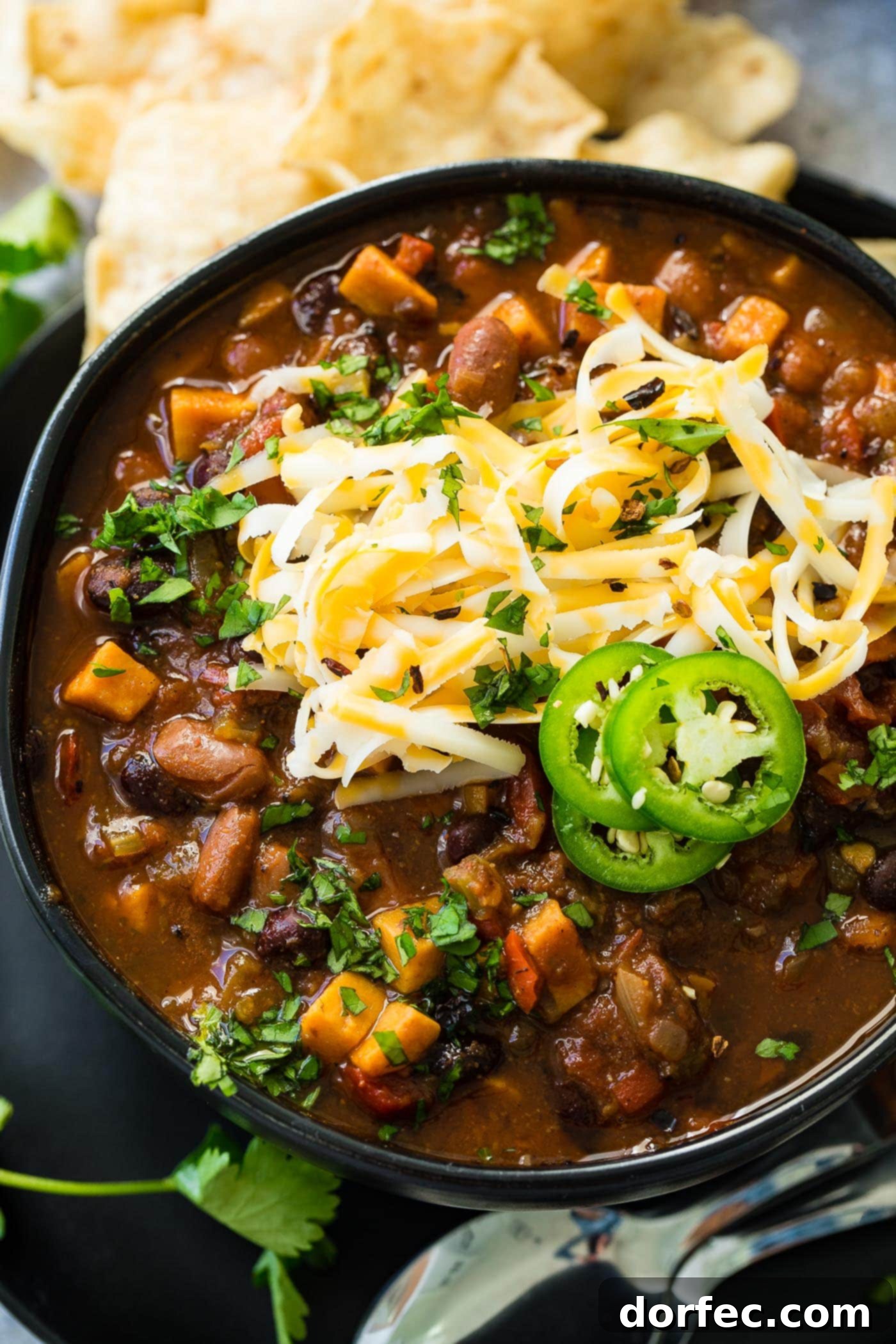 Instant Pot Vegetarian Chili A comforting bowl of Instant Pot veggie chili, beautifully presented with a topping of grated cheese and vibrant slices of fresh jalapeño, promising a wholesome and satisfying meal.