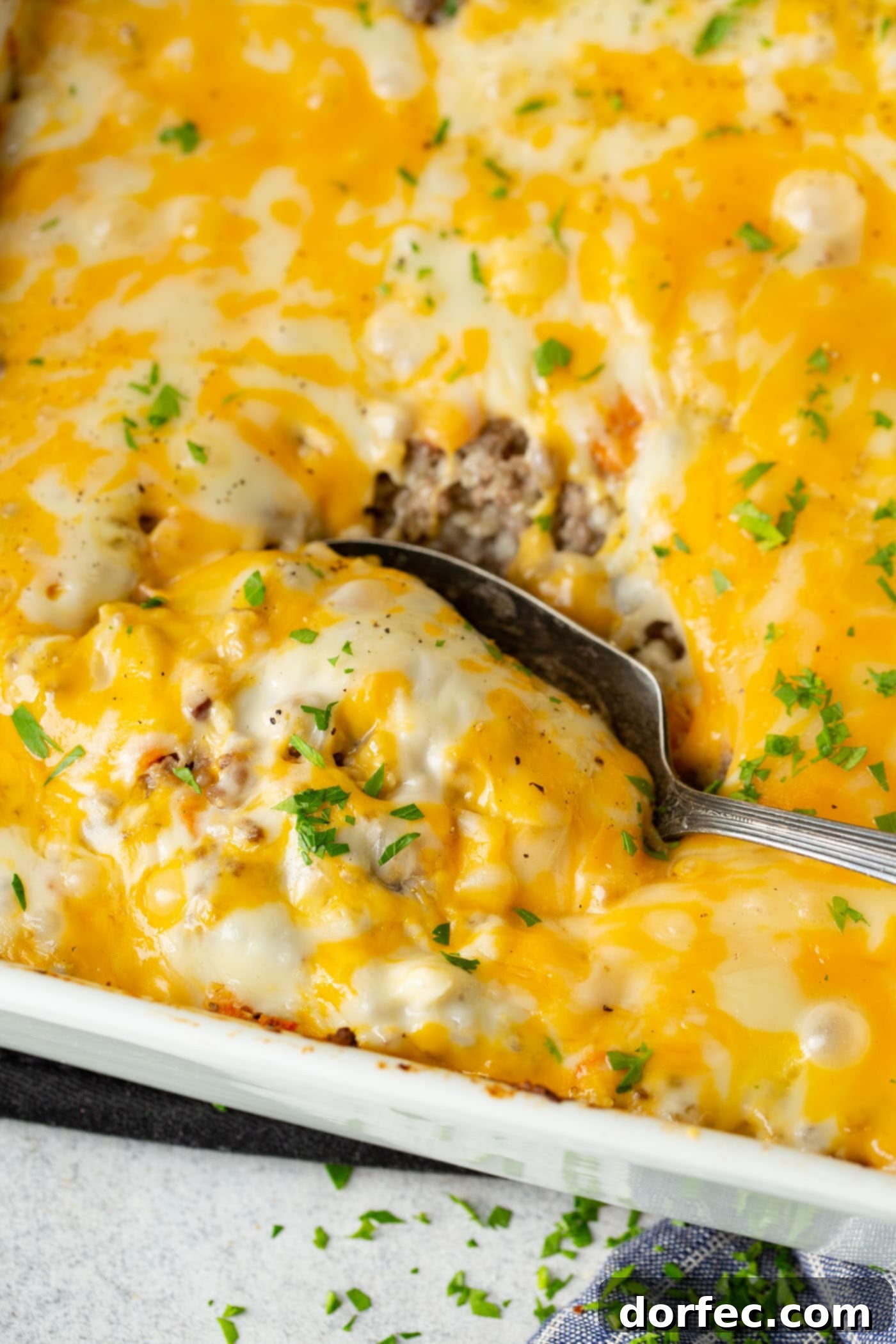 A close-up shot of a bubbling baking dish filled with the appetizing low carb cheesy ground beef and cauliflower rice casserole, fresh out of the oven, highlighting its golden-brown top and rich texture.