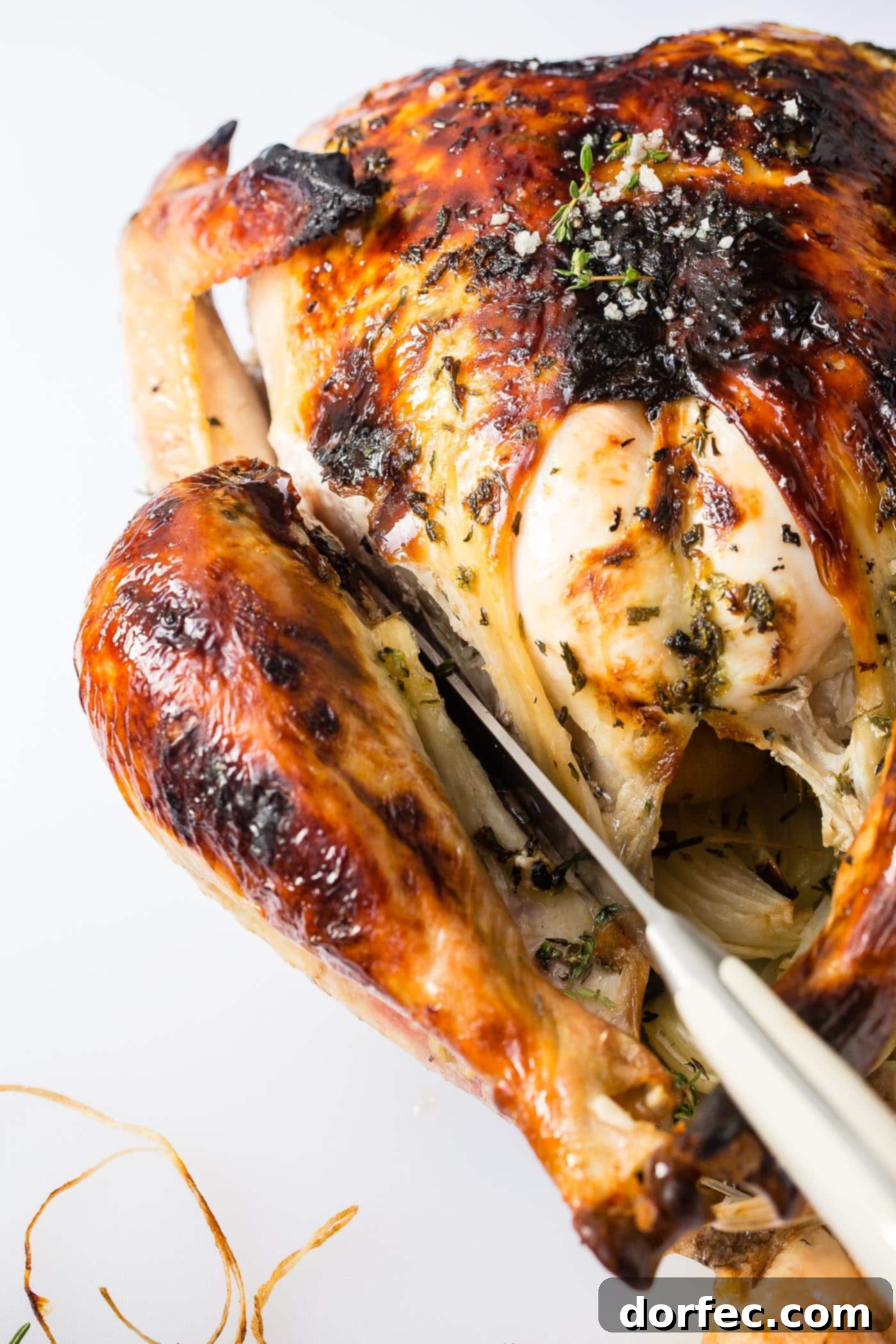 How to Carve a Turkey A close-up image showing a carving knife expertly separating the leg and thigh from a whole roasted turkey.