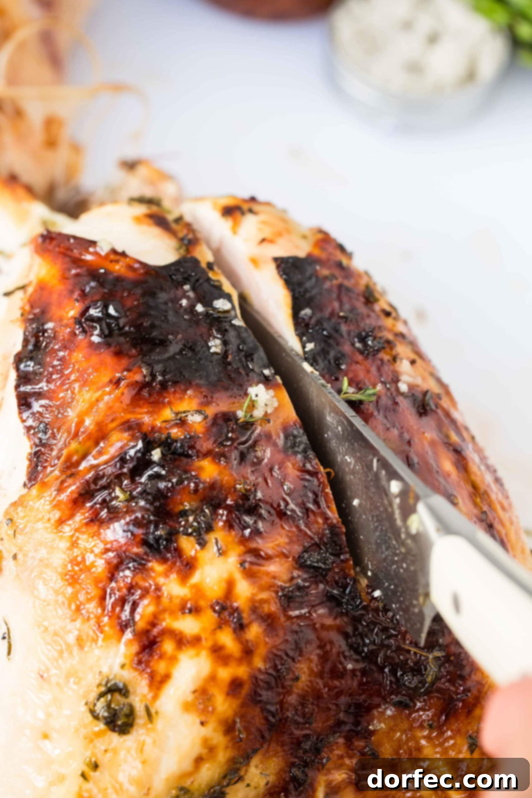 How to Carve a Turkey A carving knife expertly slicing down along the breastbone of a roasted turkey to remove the breast meat.