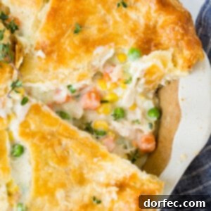 A perfectly baked whole chicken pot pie with a golden, flaky crust, ready to be served.