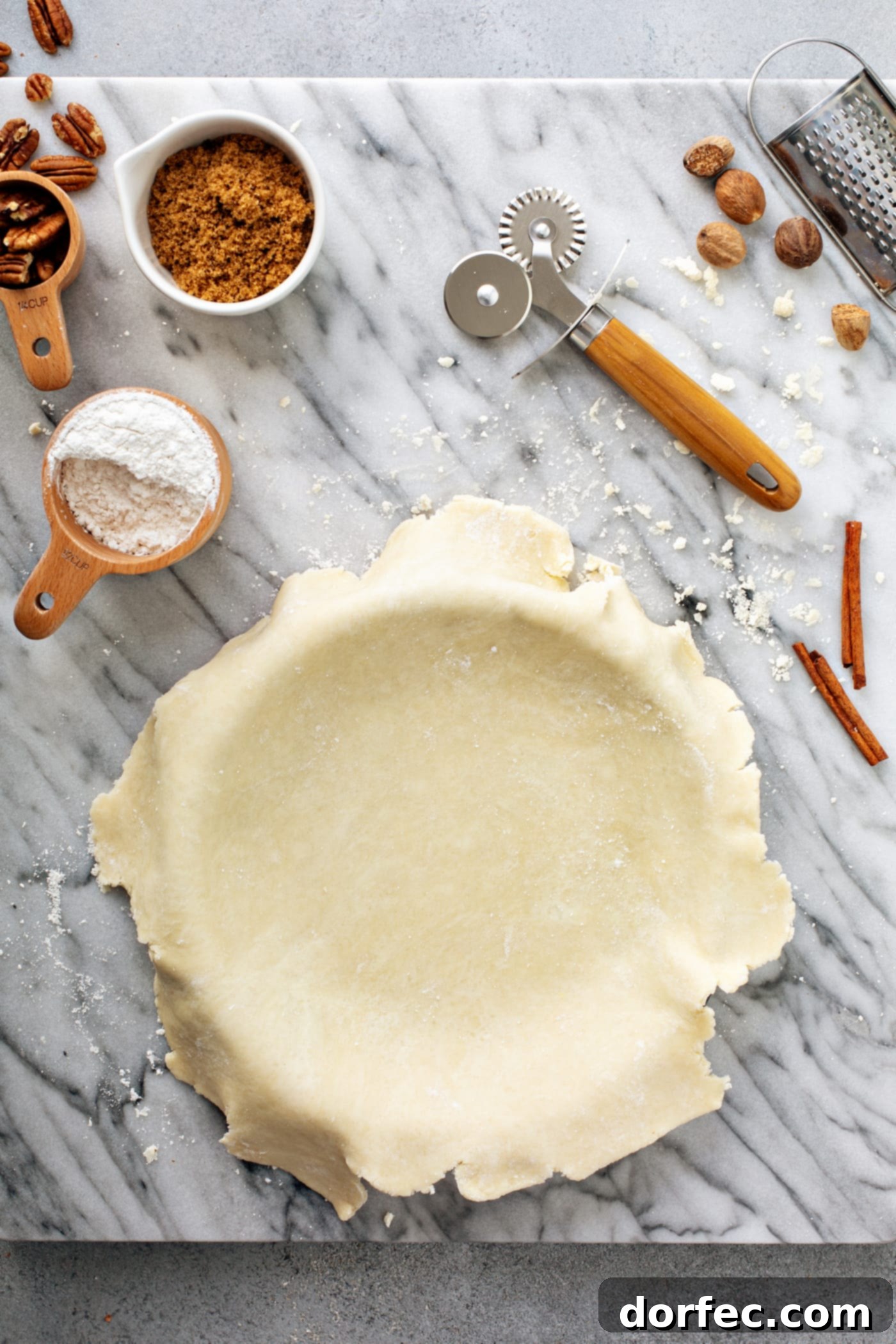 An untrimmed, uncooked pie crust draped over a pie tin, showing the raw edge before crimping or final shaping.