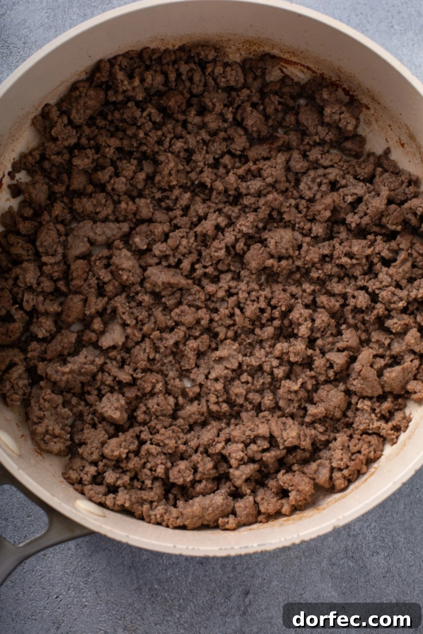 A casserole dish containing browned ground beef.