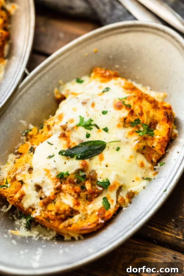 Browned Butter Pork and Butternut Squash Lasagna 2 A large serving of golden-brown butternut squash lasagna, generously topped with melted cheese and fresh, crispy sage leaves, ready to be enjoyed as a hearty comfort meal.