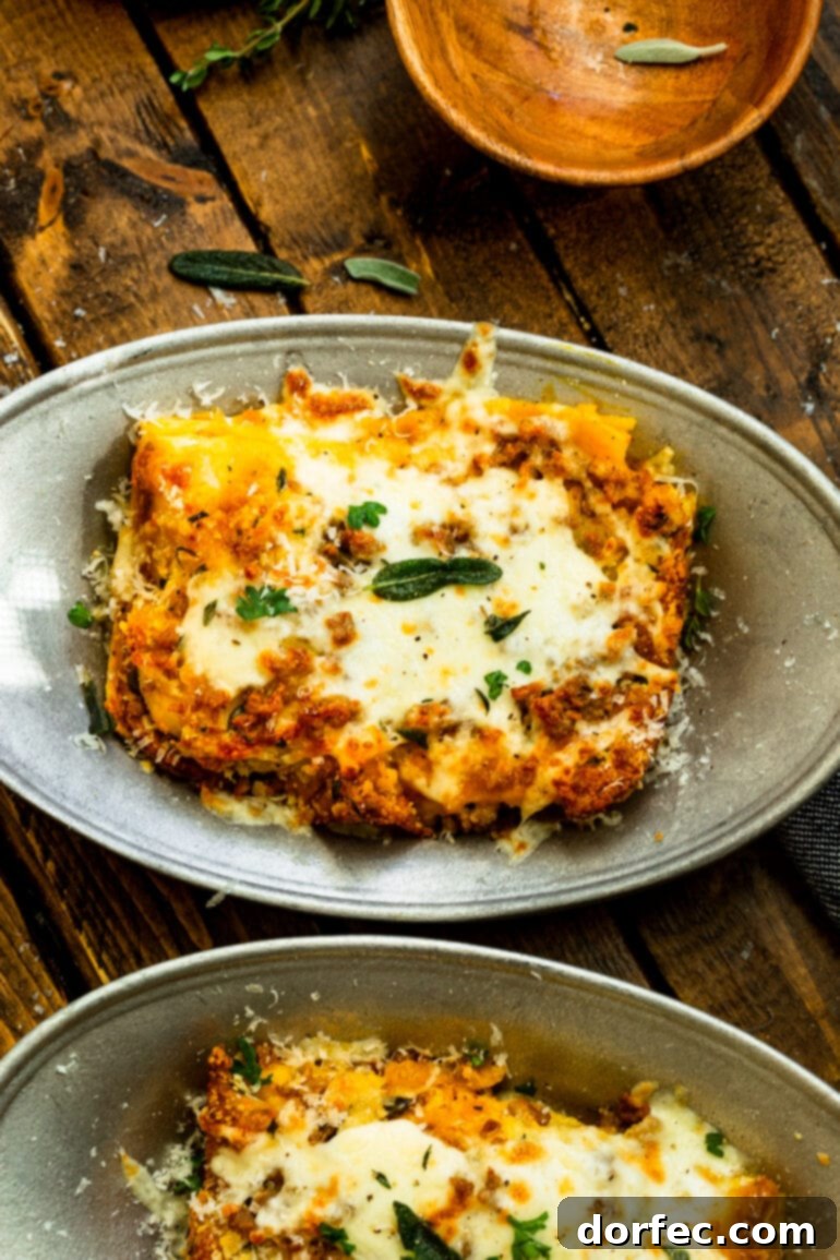 Browned Butter Pork and Butternut Squash Lasagna 5 A close-up shot of a large dish of browned butter pork and butternut squash lasagna, generously topped with melted cheese, fresh parsley, and sage, highlighting the rich, inviting textures and colors.