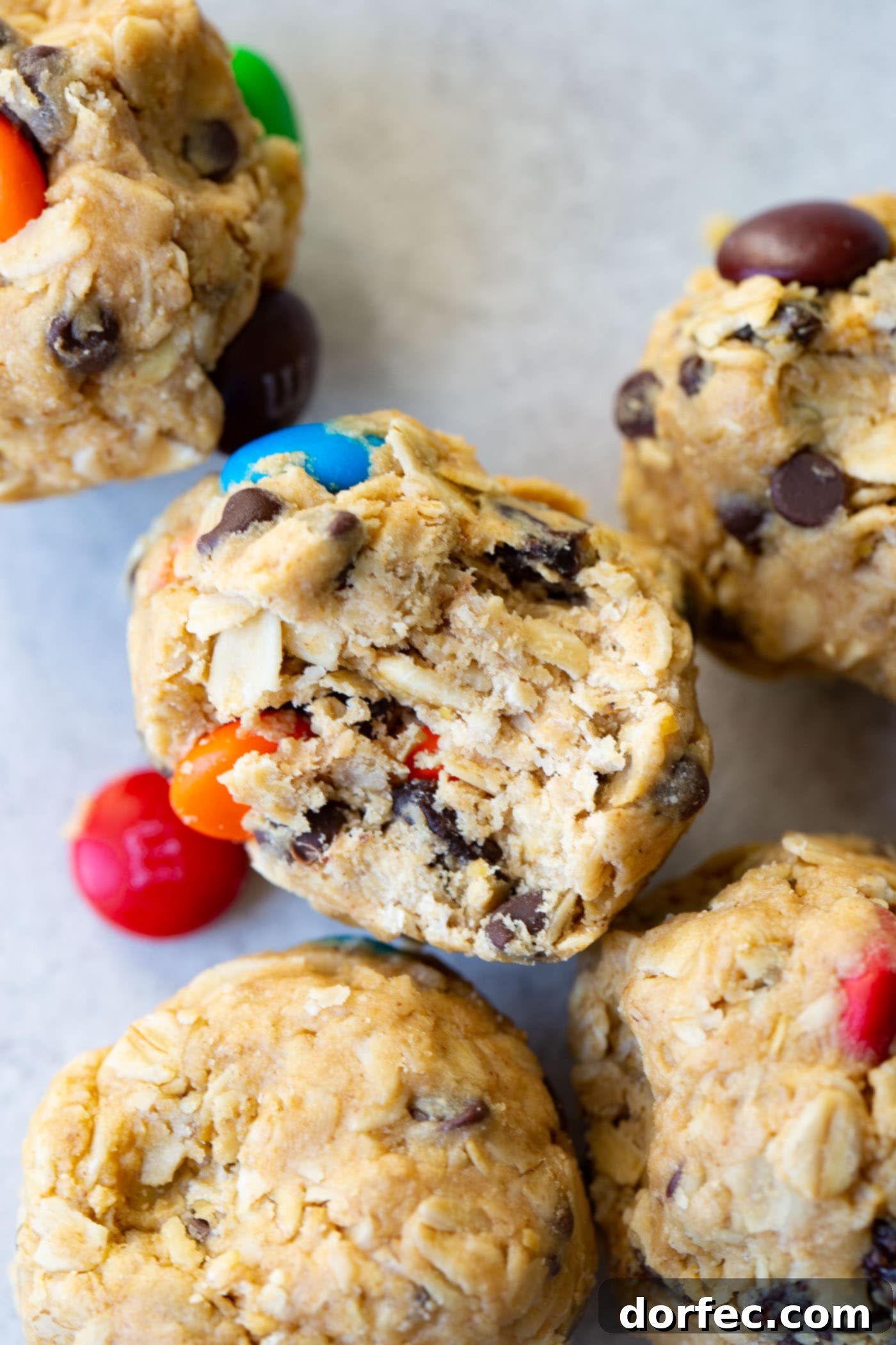 Protein-Packed Peanut Butter Monster Cookie Energy Bites 5 A close-up image of a peanut butter protein ball with a bite taken out, revealing its rich texture and colorful mix-ins.
