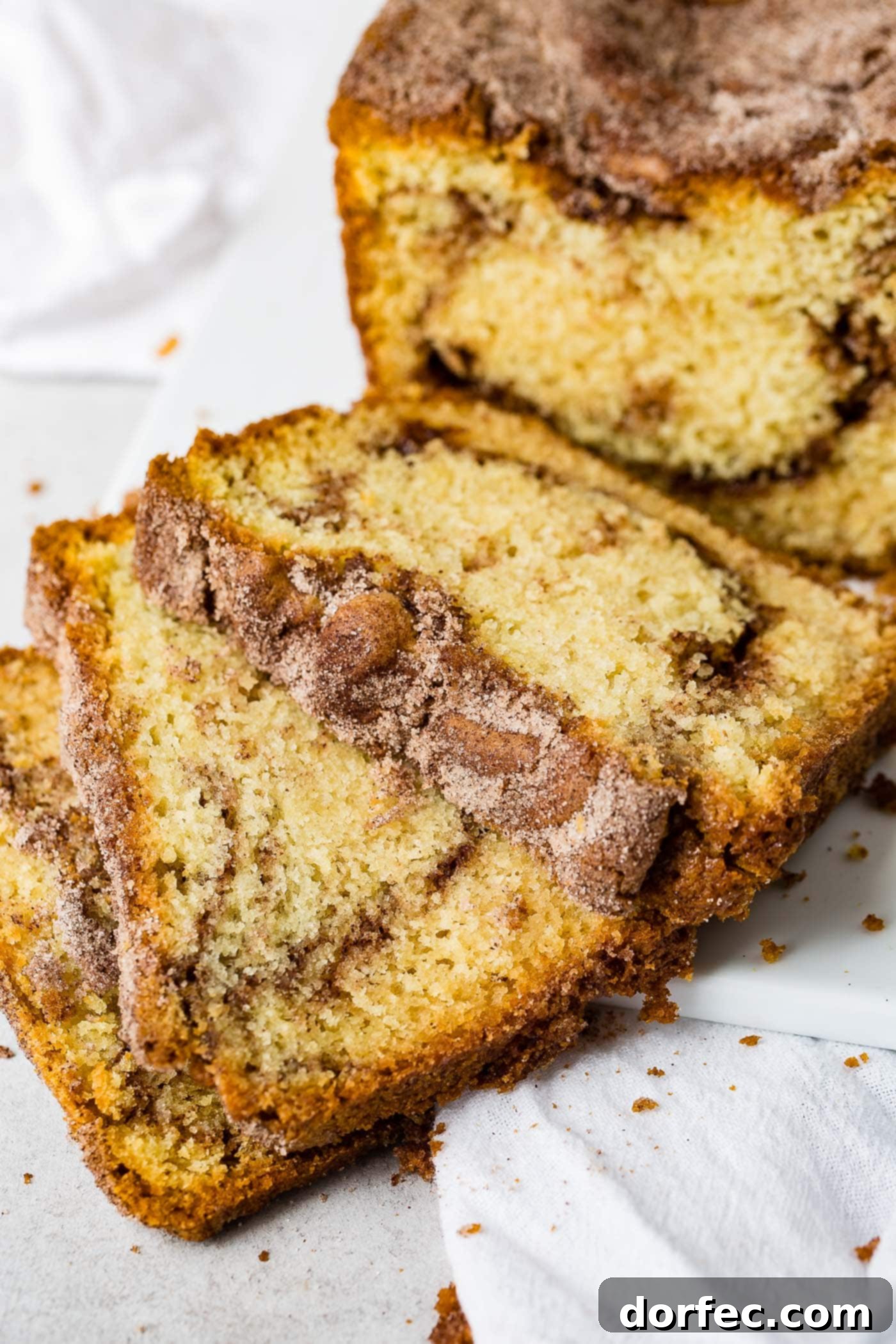 Cinnamon Sugar Swirl Loaf 4 Close-up of three slices of Snickerdoodle Bread, showcasing the intricate cinnamon sugar swirl and the fluffy texture. The bread is sprinkled with cinnamon sugar for extra flavor and a crisp crust.