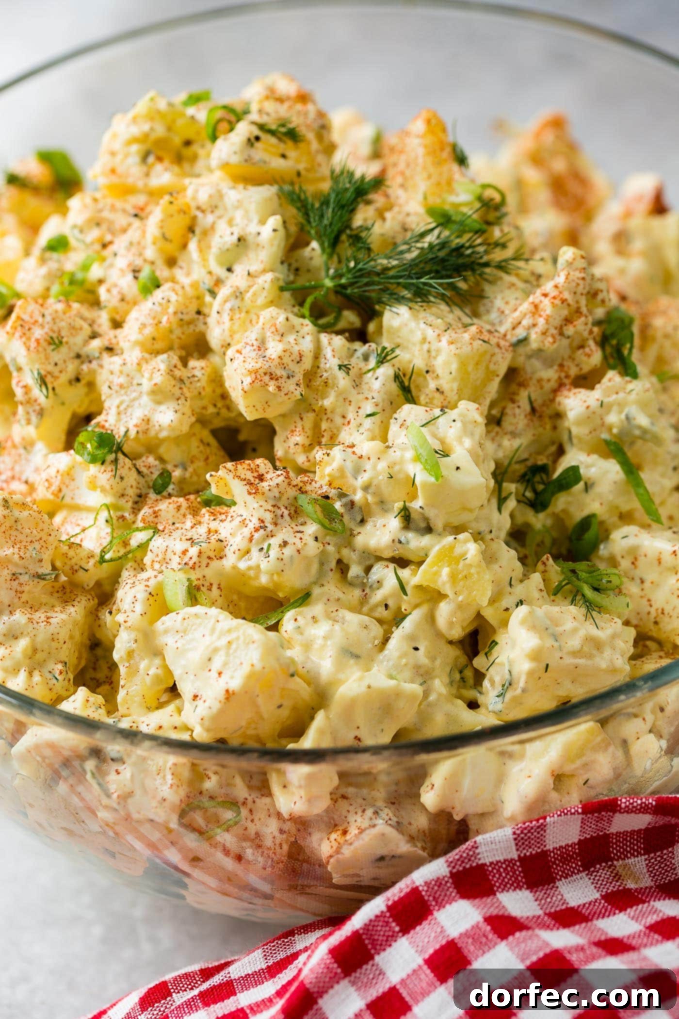 The Only Potato Salad Recipe You'll Ever Need 4 A glass bowl of potato salad. The chunks of potato, pickles, and eggs are mixed together in a perfect dressing. The salad is sprinkled with paprika and fresh parsley.