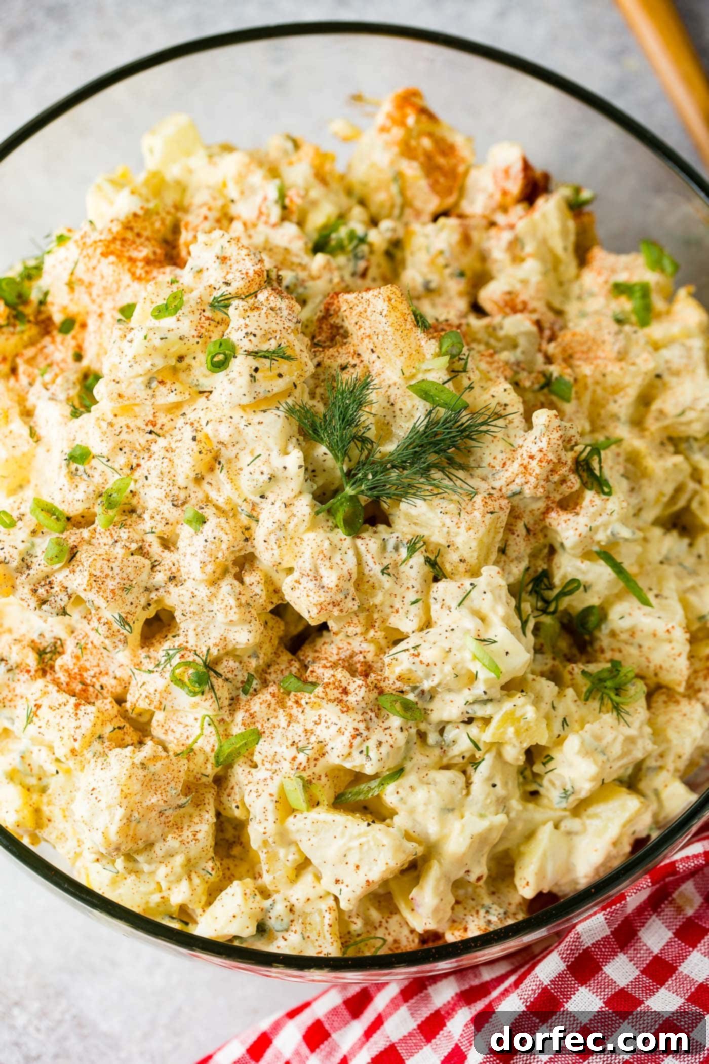The Only Potato Salad Recipe You'll Ever Need 5 A glass serving bowl filled with potato salad. There are chunks of potato, chopped pickles, chopped eggs and dill in the salad. Paprika and fresh parsley is sprinkled on top.