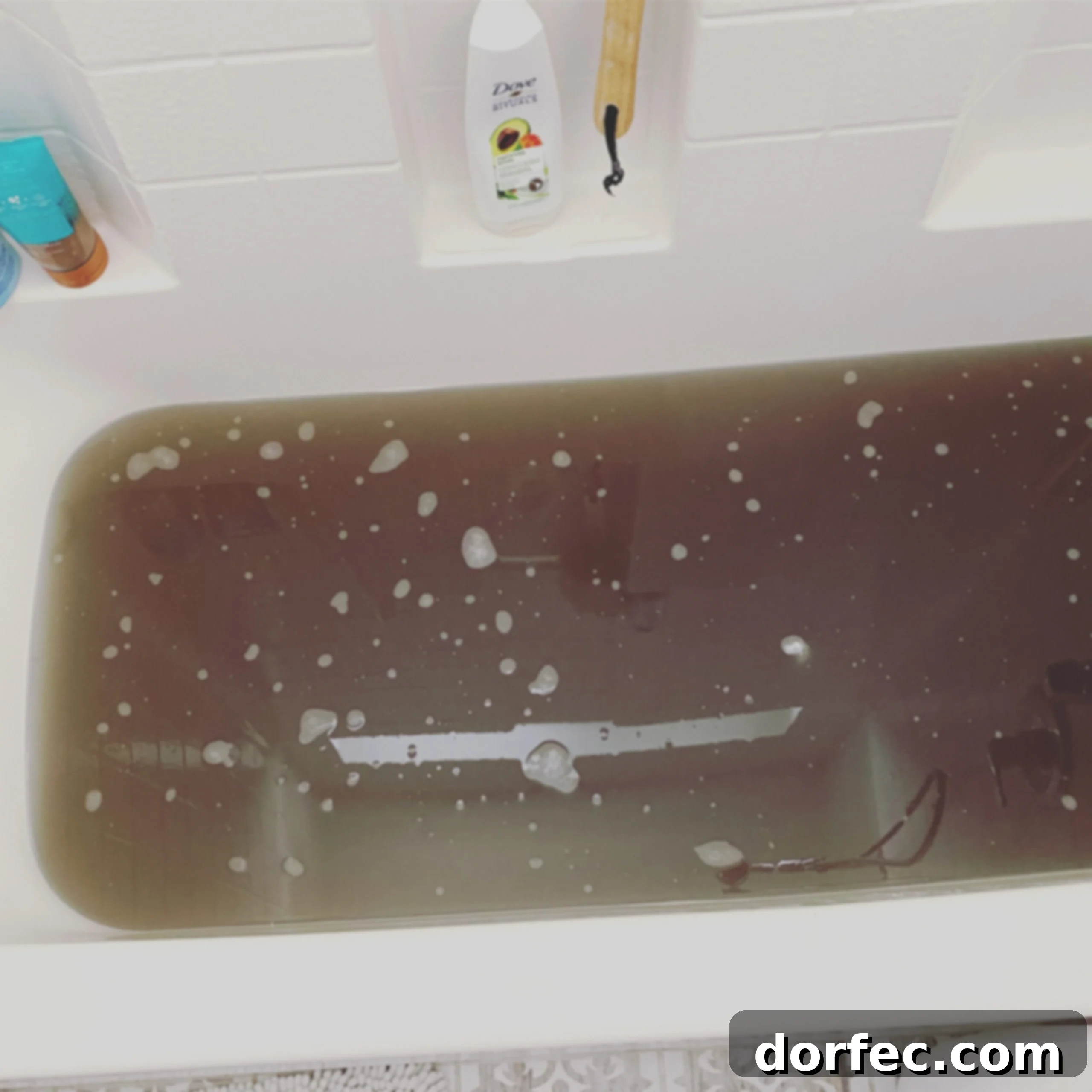 Unlock the Secret to Truly Clean Laundry 3 a bathtub full of murky water from stripping laundry, demonstrating the dirt removed from fabrics