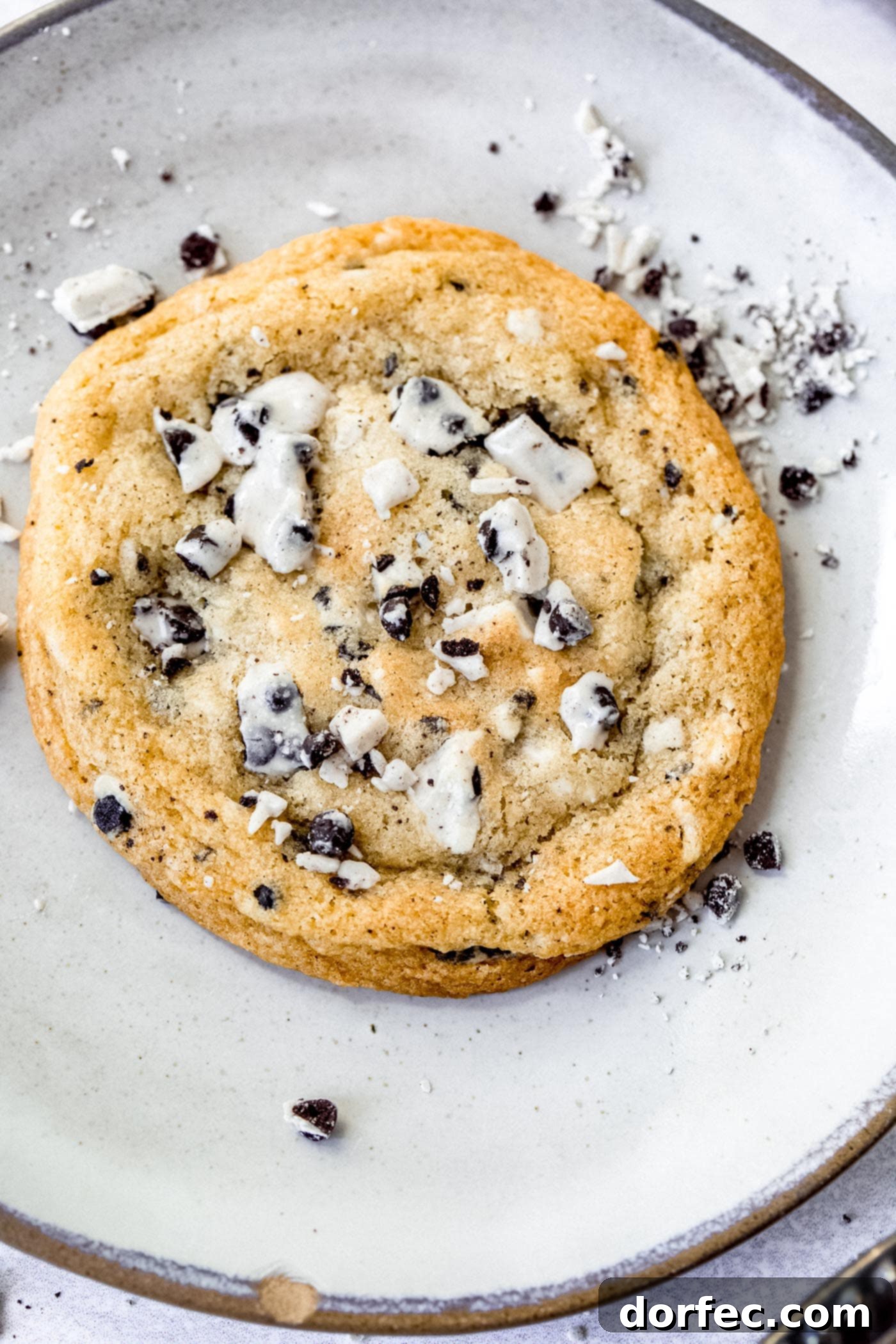 A large cookies and cream cookie. The cookie is loaded with bits of cookies and cream candy bar.
