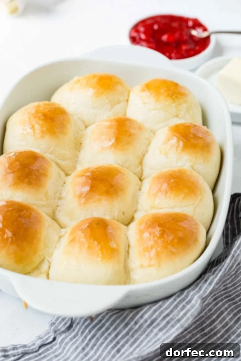 A baking dish with white dinner rolls that have been baked to a golden brown.
