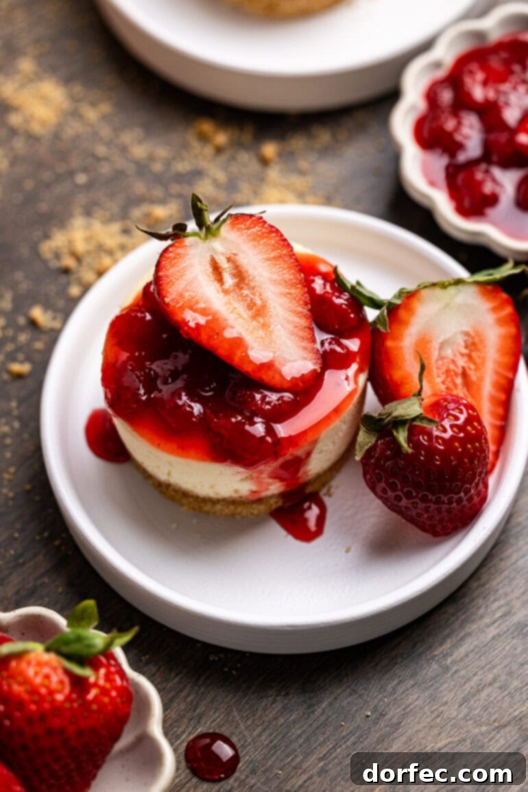Strawberry Cheesecake Bites 6 An overhead shot of a perfectly portioned mini strawberry cheesecake, glistening with strawberry topping and garnished with fresh strawberry slices, ready to be enjoyed.