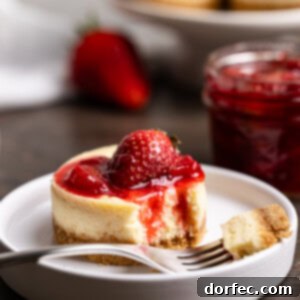 Strawberry Cheesecake Bites 9 A vibrant square image showcasing a finished mini strawberry cheesecake, beautifully plated with fresh berries and a generous swirl of sauce.