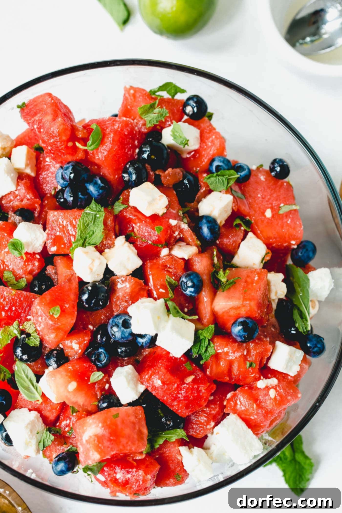 Blueberry Feta Watermelon Salad A serving dish filled with blueberry feta watermelon salad, highlighting the juicy watermelon, plump blueberries, and crumbly feta cheese, all tossed with aromatic basil and mint.
