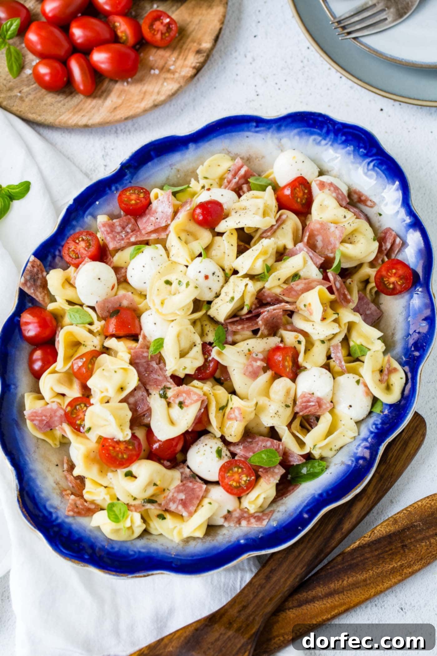 5 Minute Italian Salami Tortellini Salad A serving dish of 5 minute Italian salami tortellini salad. There are chunks of salami, sliced tomatoes and mozzarella balls mixed in with the tortellini..
