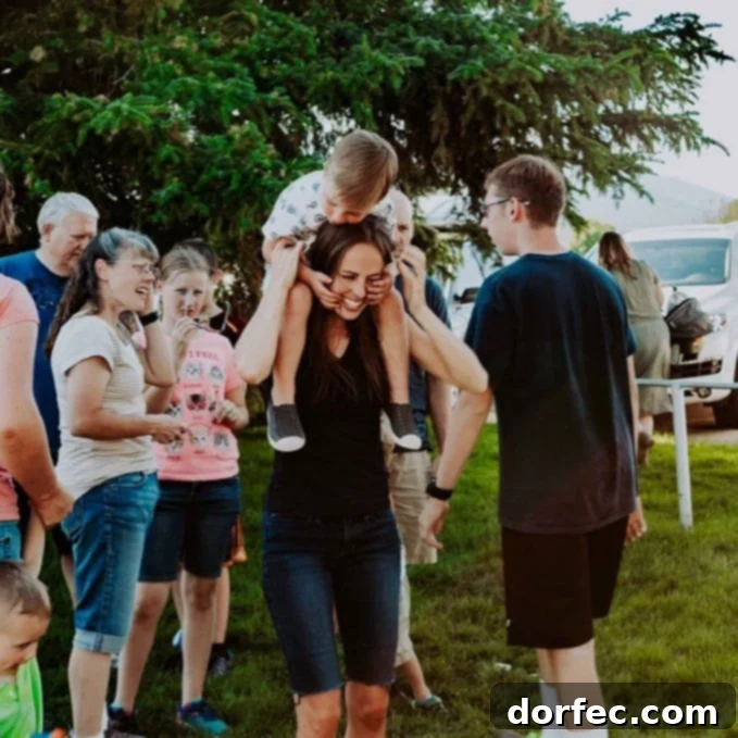 A photo of a boy on his mom's shoulders surrounded by family.