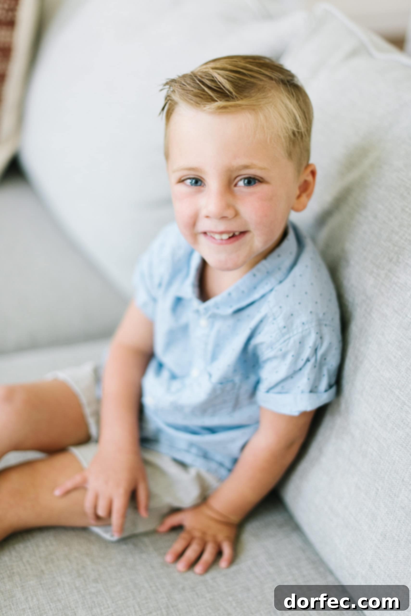 A young boy sits thoughtfully on a couch, embodying innocence and the simple realization of life.