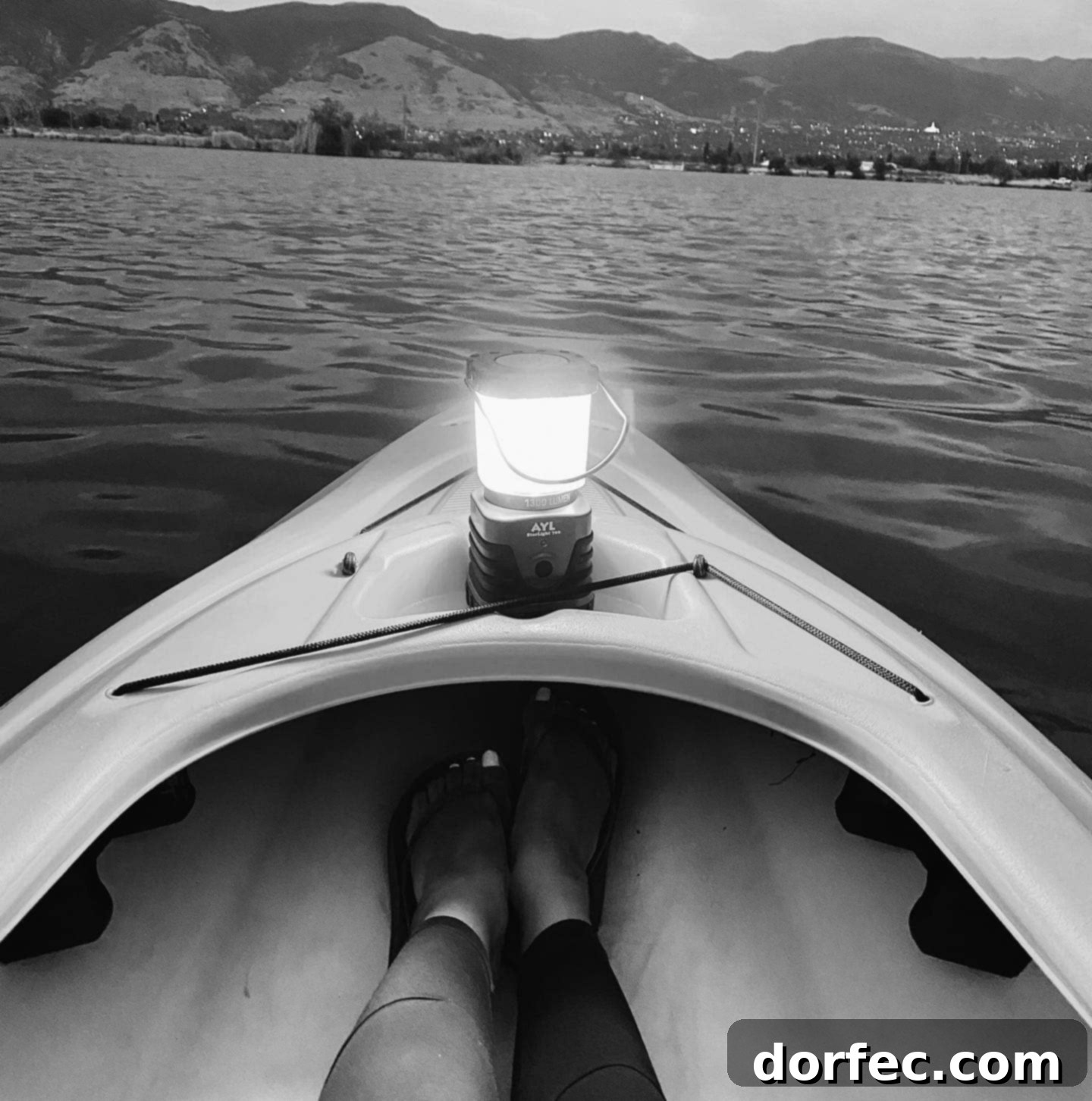 A serene night-time photograph of a person kayaking on calm water under a soft, moonlit sky. The scene evokes peace, subtle beauty, and gentle guidance.
