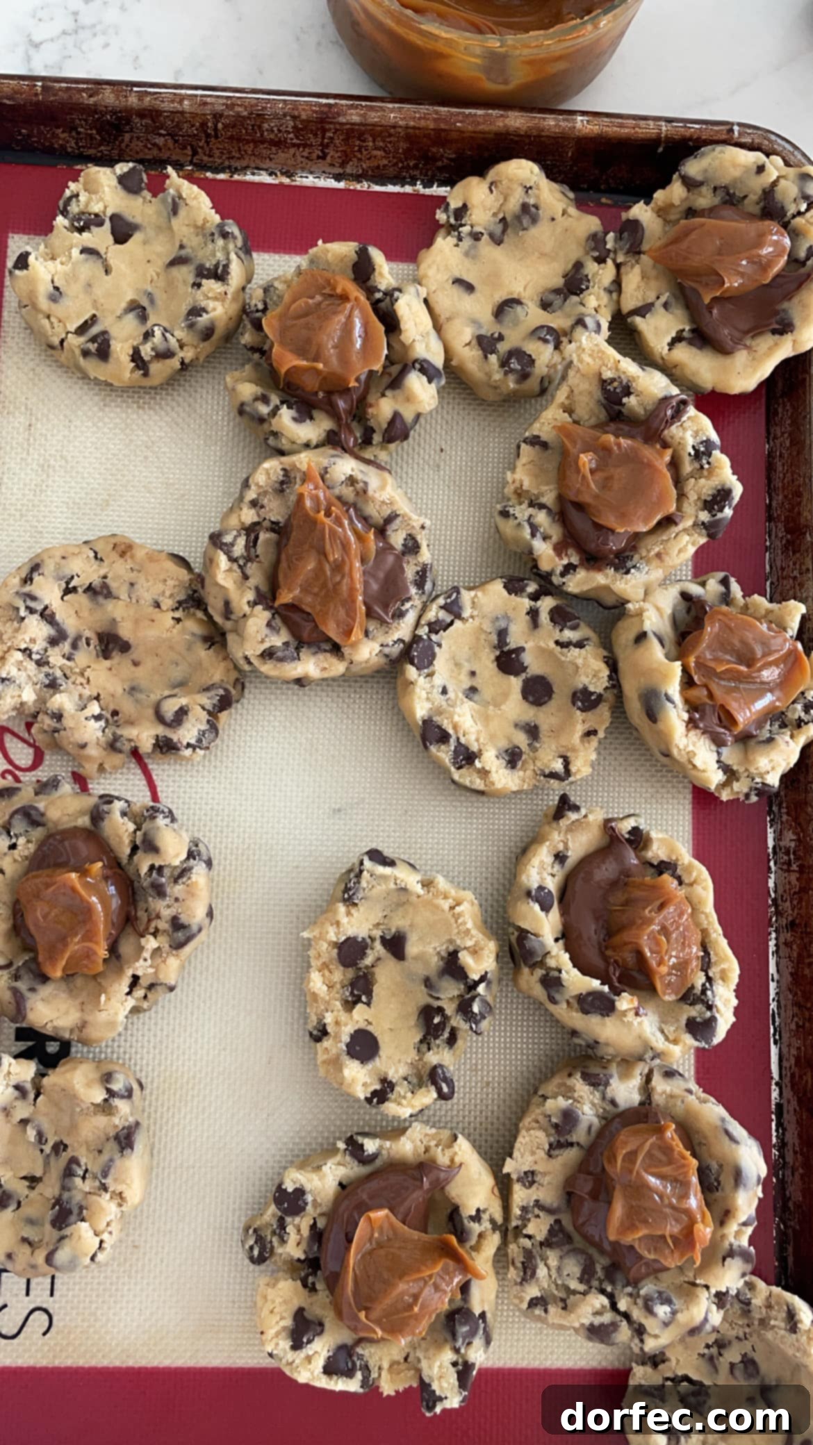 nutella and dulce de leche scooped into chocolate chip cookie dough 