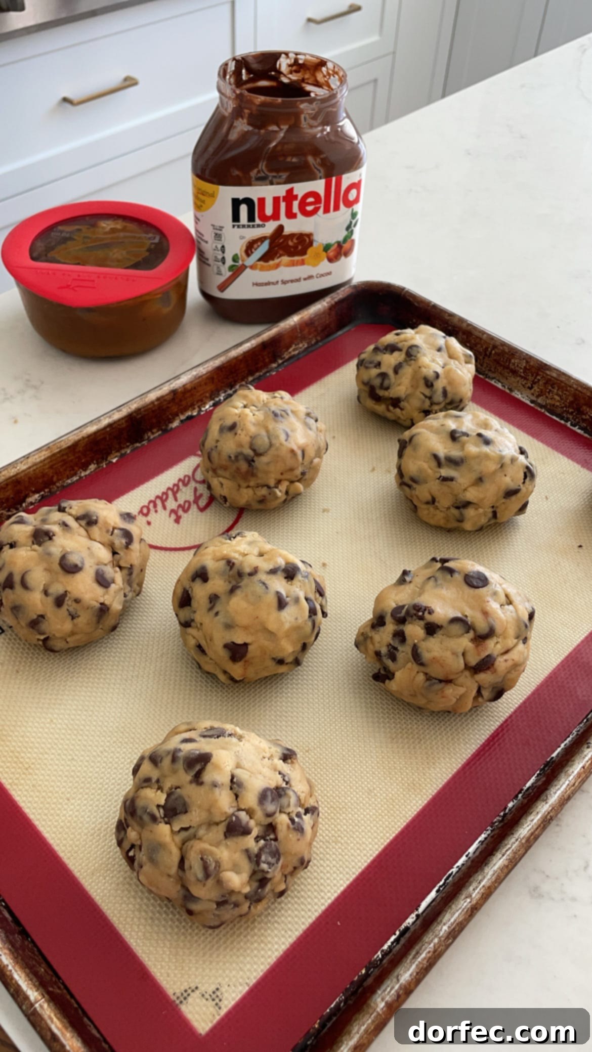 Chocolate chip cookie dough stuffed with nutella and caramel and then pinched closed to bake