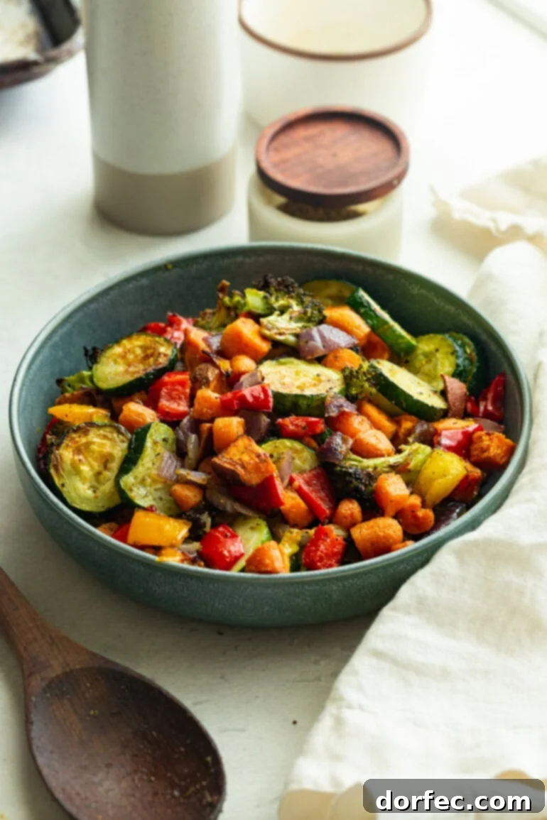 Golden Roasted Vegetable Medley 2 Crispy-tender vegetables piled in a blue bowl, showcasing the mix of orange, green, red, and yellow in every bite.