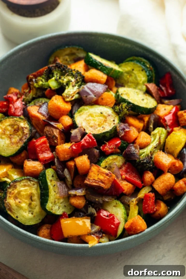 Golden Roasted Vegetable Medley 8 Roasted vegetables in a blue bowl, the colors and textures popping against the clean, minimal background.