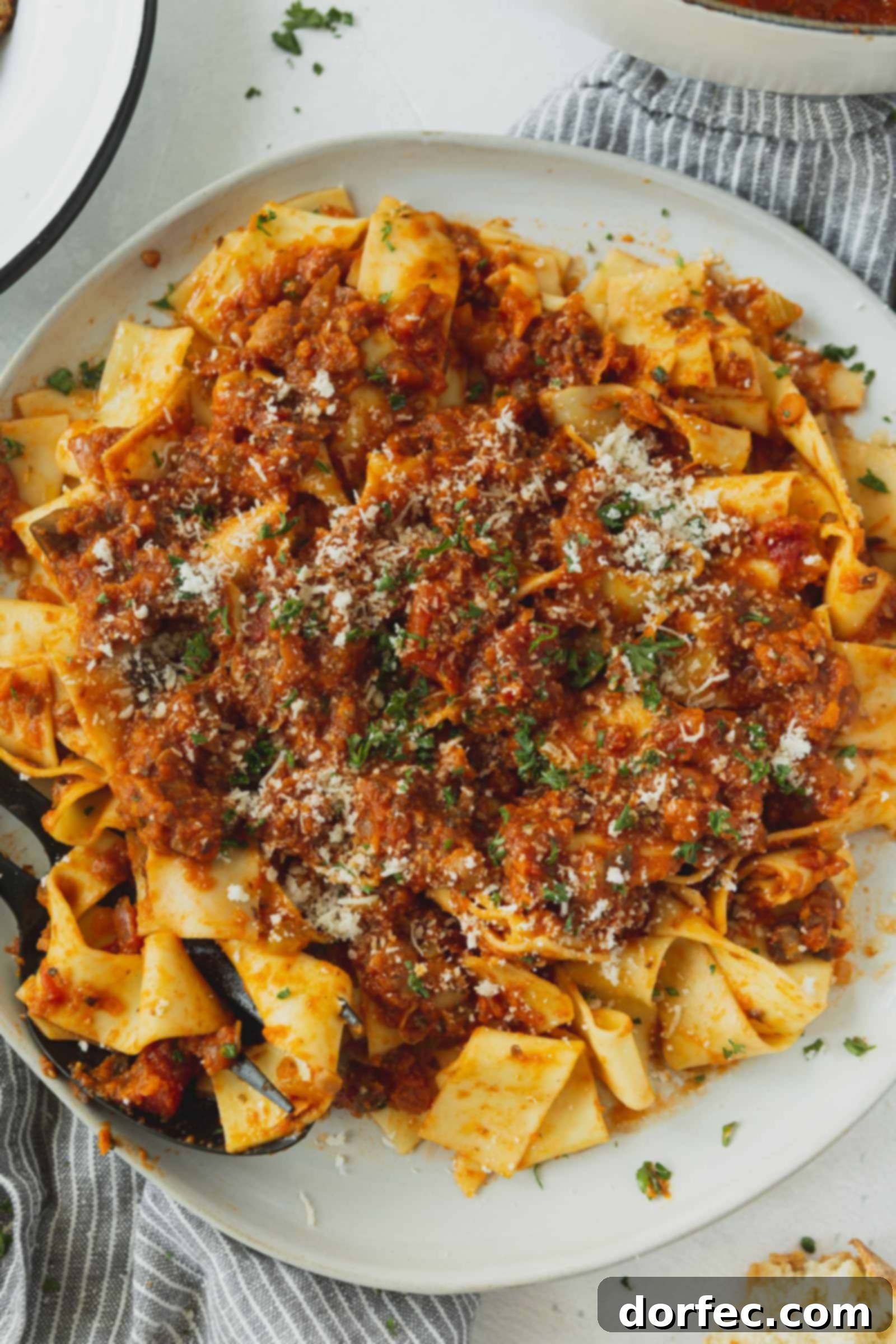 Pasta with bolognese sauce. A little grated cheese and chopped cilantro is on top.