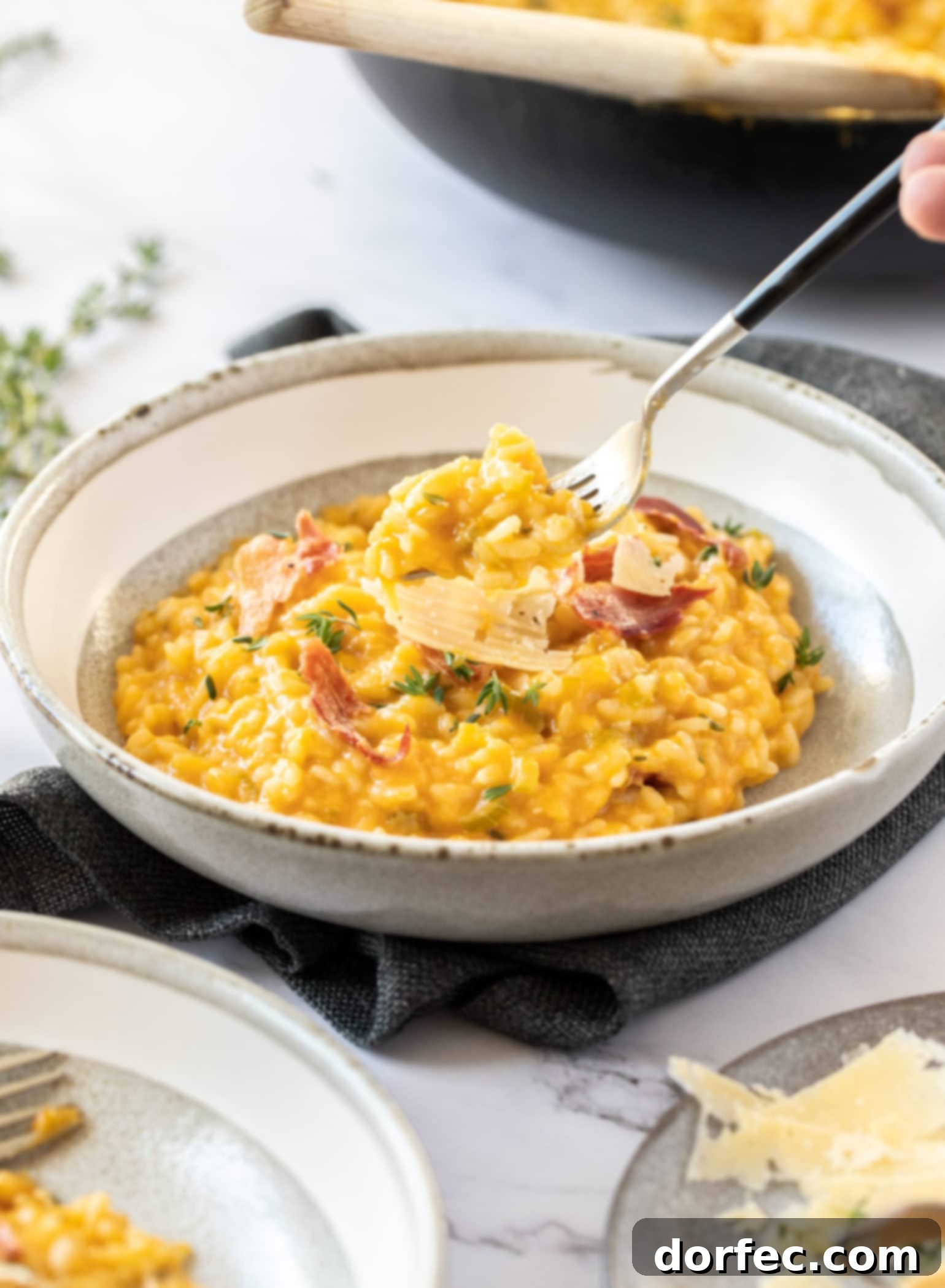 Creamy Sweet Potato Risotto 3 A closer view of the creamy orange-colored sweet potato risotto in a grey bowl, highlighting its rich texture.