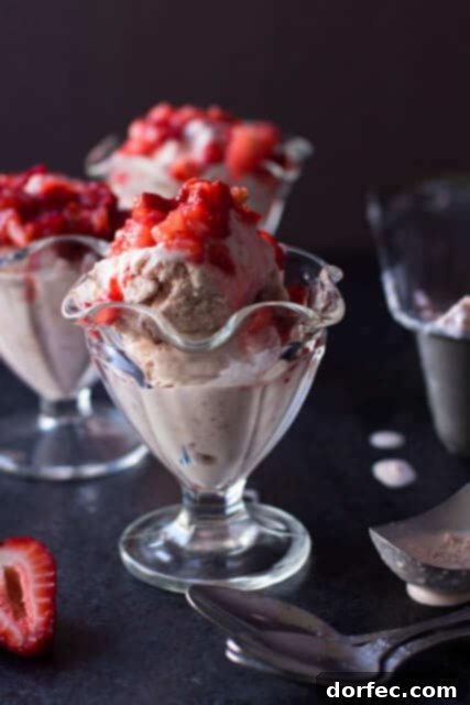 A bowl of creamy, homemade strawberry ice cream, garnished with fresh strawberries, embodying the spirit of summer desserts and simple pleasures.