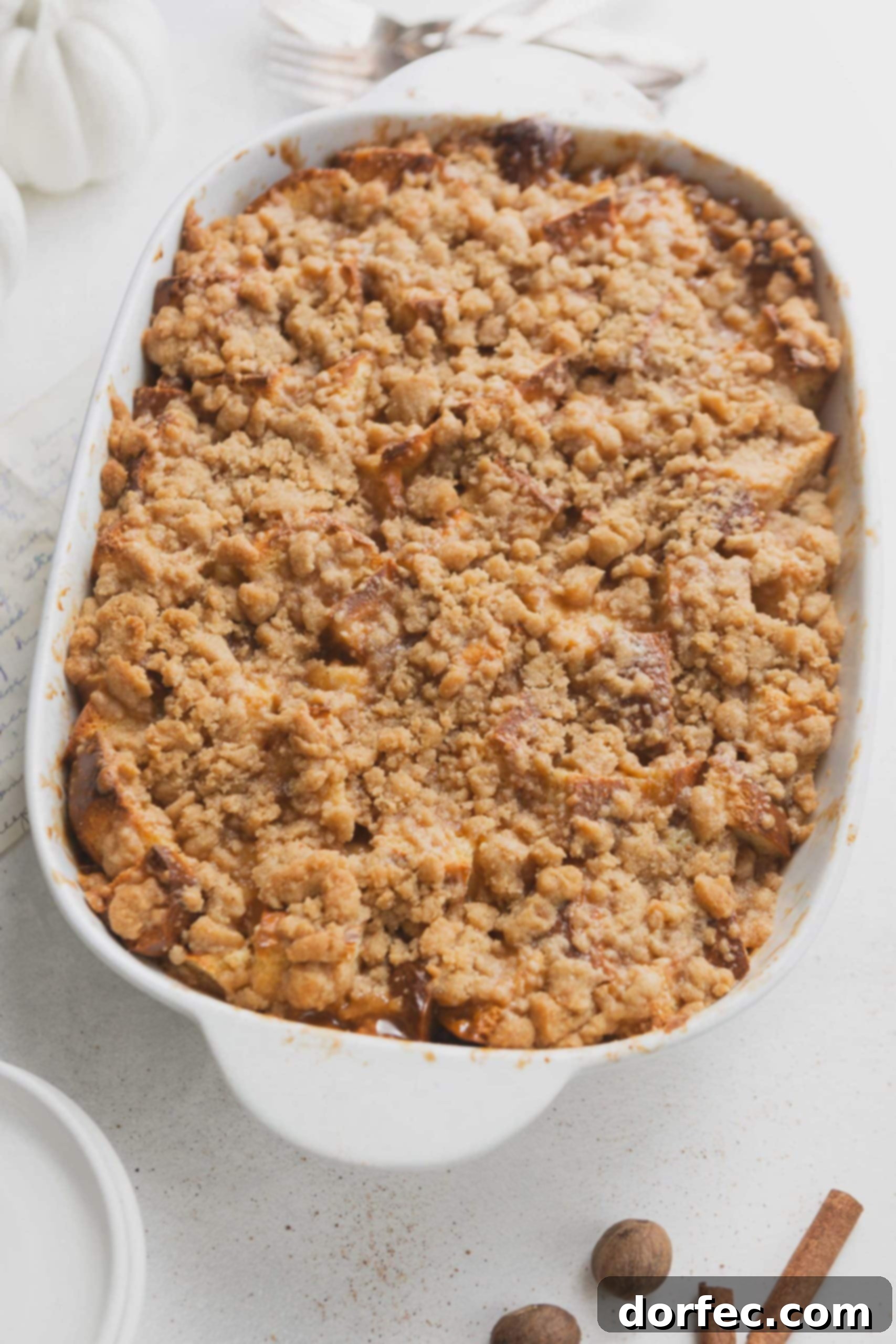 A casserole dish with eggnog french toast. The French toast is topped with a crumb topping.
