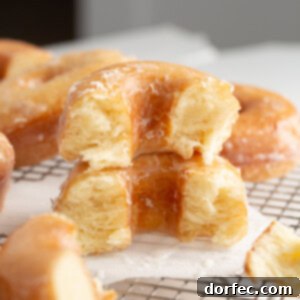 A delightful stack of golden, glazed homemade donuts, showcasing their perfect shape and irresistible sheen.