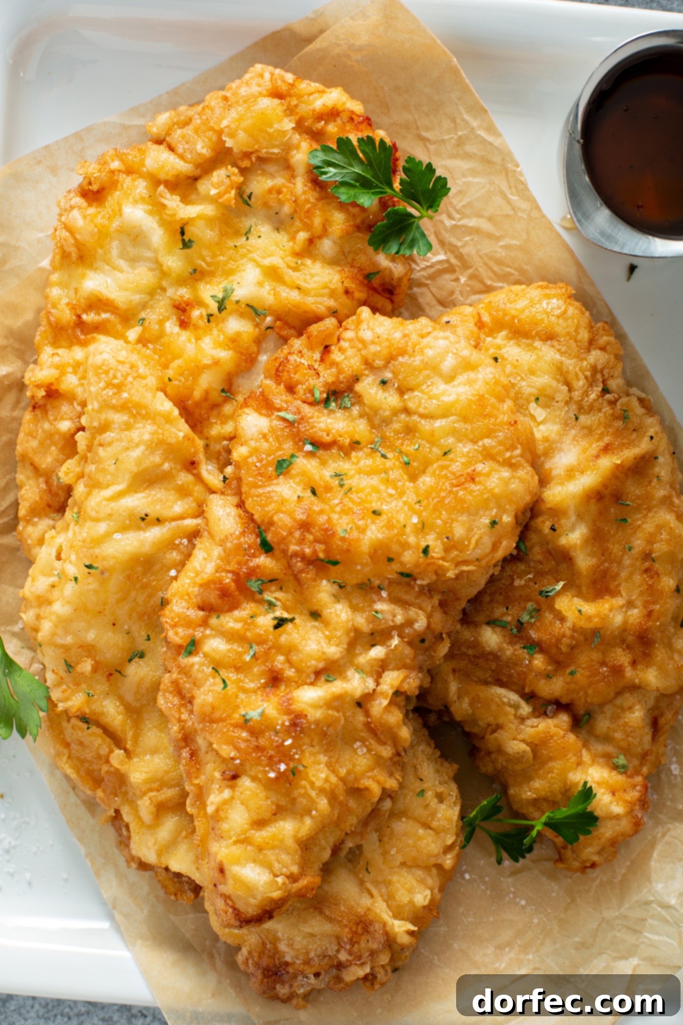 Authentic Southern Crispy Fried Chicken 7 A serving platter heaped with golden fried chicken. A few parsley leaves are scattered on top.