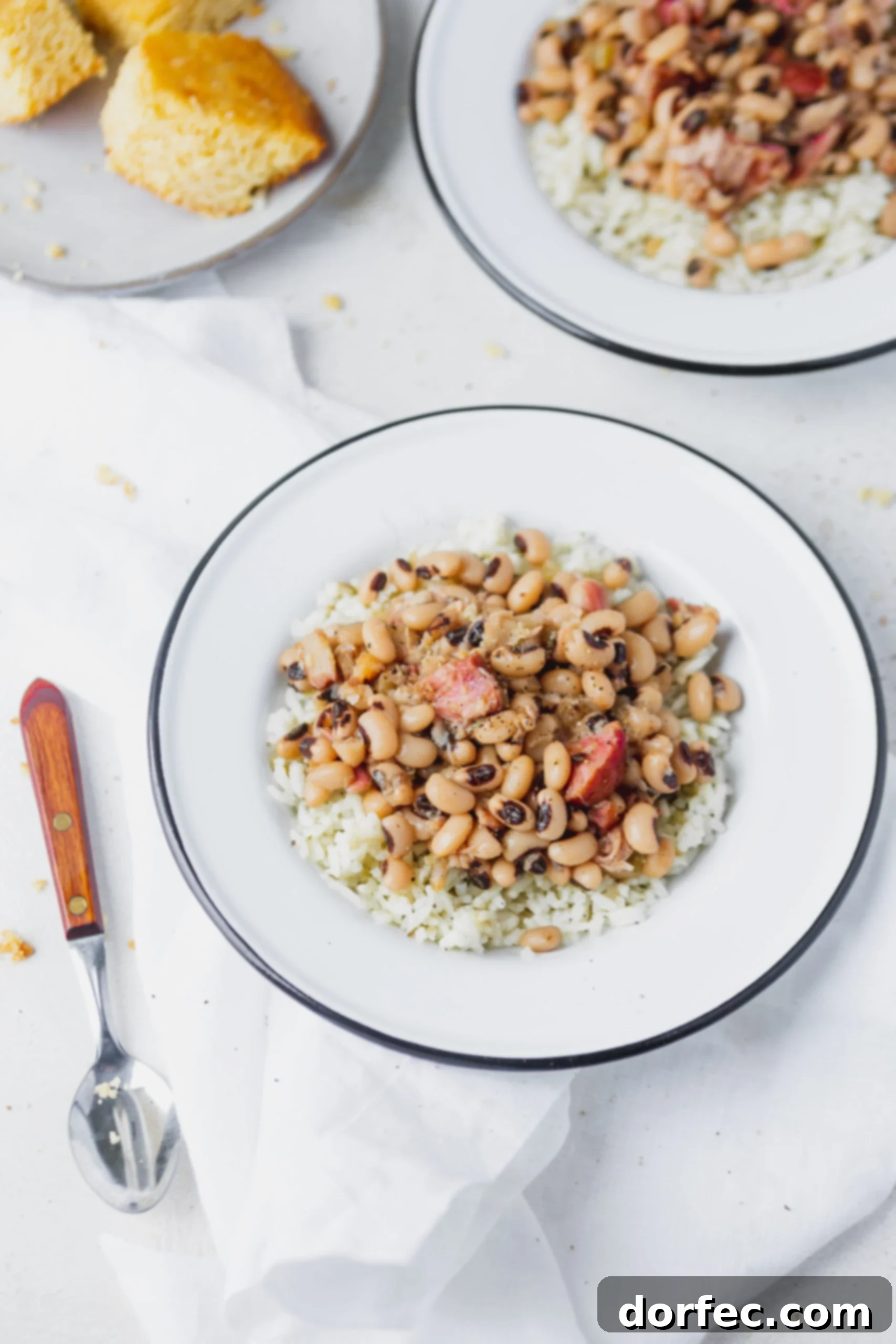 Instant Pot Black Eyed Peas A white plate with Instant Pot black eyed peas over rice. A spoon is next to the plate.