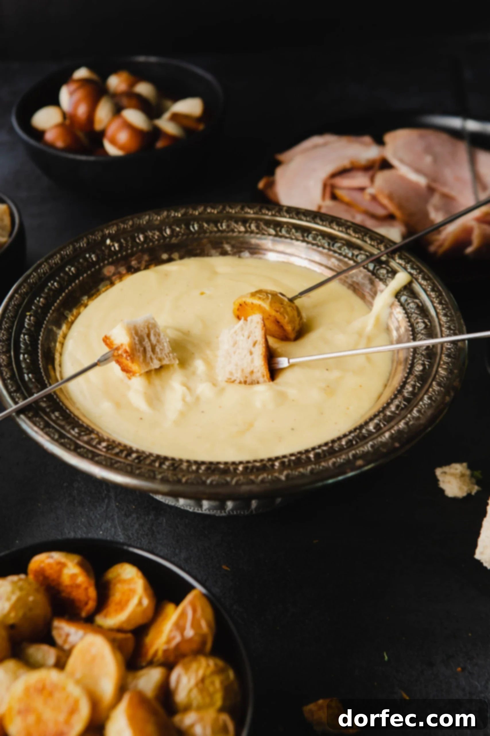 Perfect Cheese Fondue and What to Dip in Fondue A vibrant display of cheese fondue, perfect for a gathering. A gleaming fondue pot filled with smooth, golden cheese is at the center. Skewers laden with crusty bread are being dipped, and a colorful array of dippers surrounds the pot: fresh fruit slices, hearty bread cubes, succulent meats, and crisp vegetables.