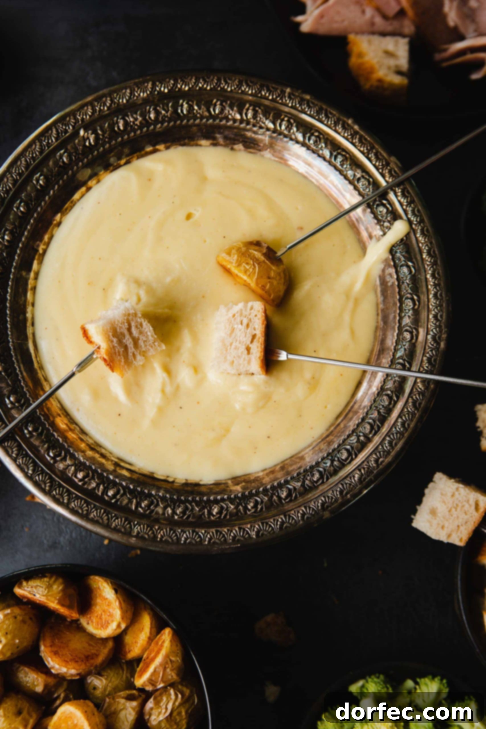 Perfect Cheese Fondue and What to Dip in Fondue A close-up shot of a perfectly smooth bowl of cheese fondue, ready for dipping. A fondue skewer, impaled with a piece of golden-brown bread, is gracefully lifted, showcasing the rich, melted cheese clinging to it. The focus on the creamy texture highlights the irresistible nature of the dish.