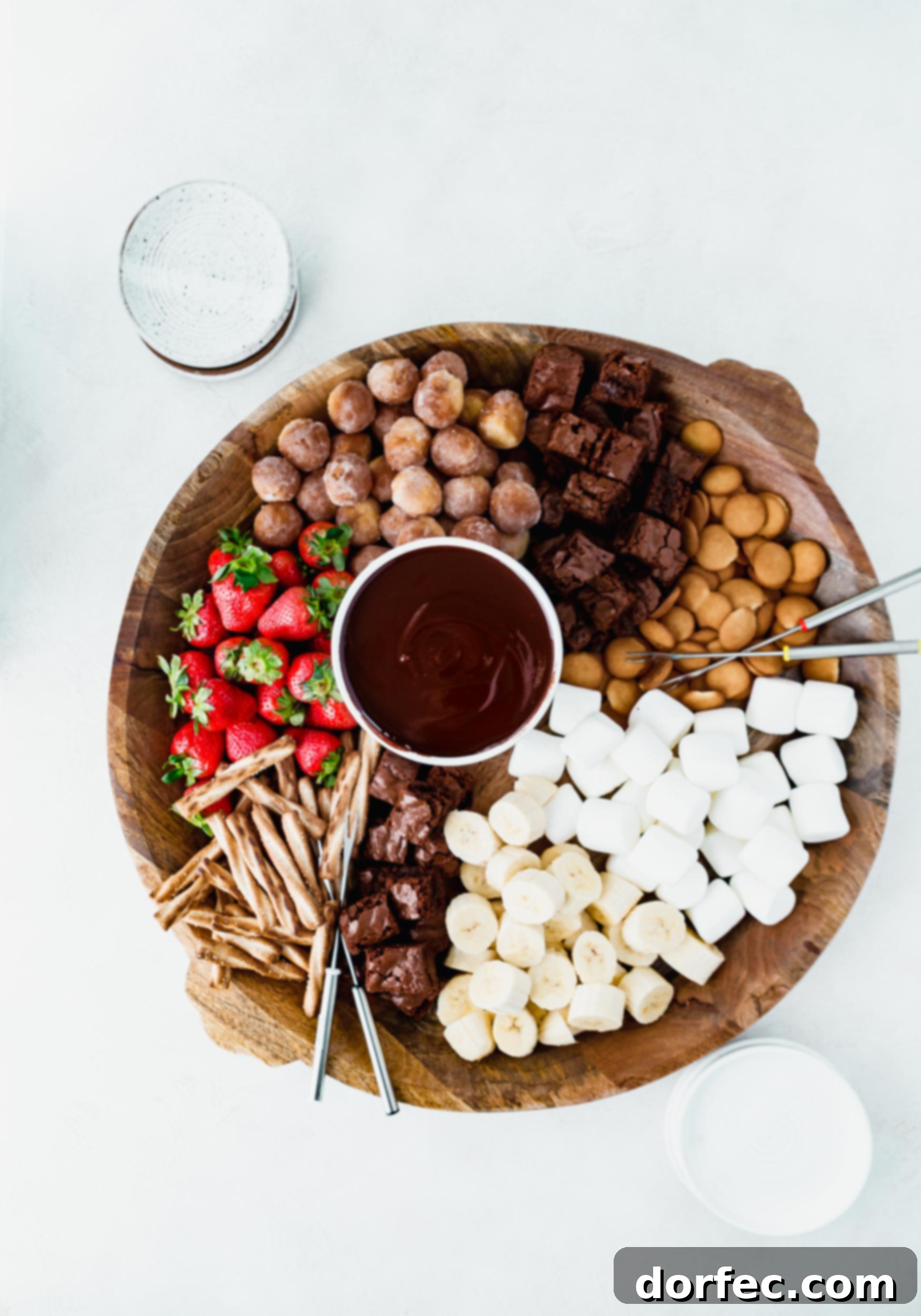 Chocolate Fondue Spread A tray with a bowl of chocolate fondue surrounded with strawberries, bananas, brownies, marshmallows, and cookies to dip into the fondue.