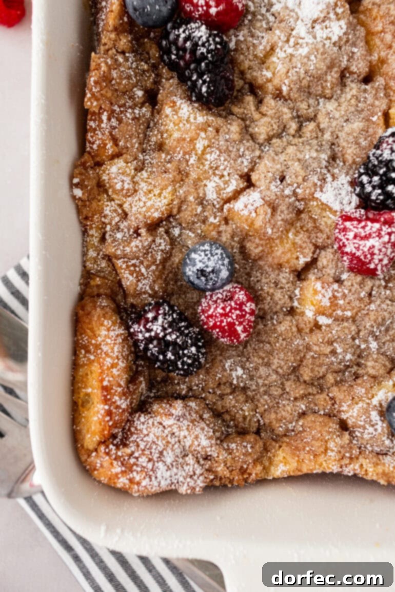Overnight French Toast Bake 10 An overhead view of a French toast casserole, freshly baked with a golden-brown streusel topping, still in its baking dish.