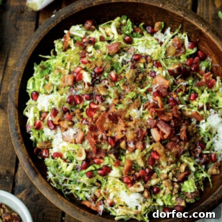 Jewel-Toned Brussels Sprouts with Pomegranate 6 A large, inviting bowl filled with warm Brussels sprouts salad, generously topped with crispy bacon, ruby-red pomegranate arils, golden toasted nuts, and delicate shavings of Manchego cheese, all glistening with apple cider vinaigrette.