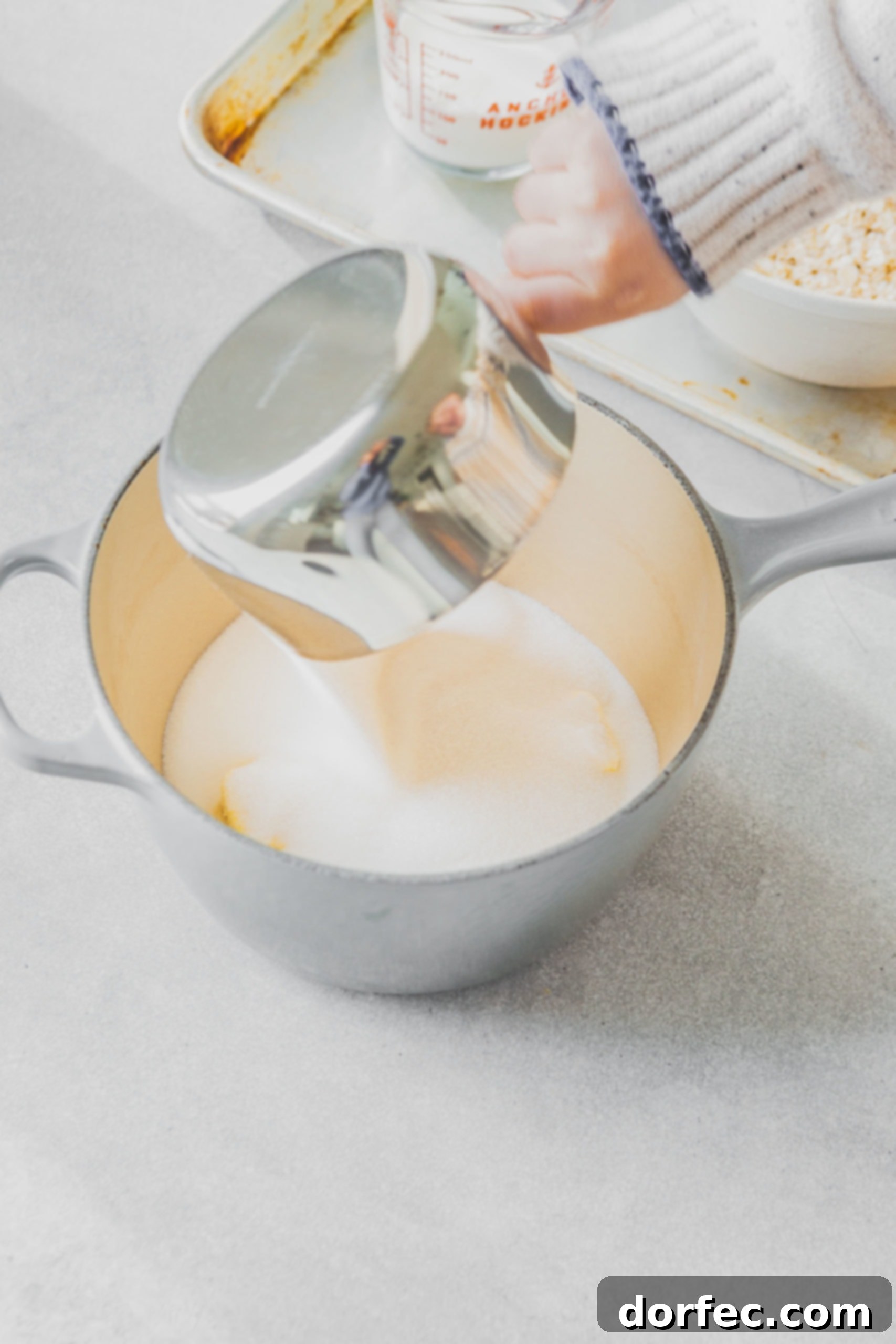 A saucepan on the stove, containing a mixture of sugar, milk, and butter, just beginning to heat.