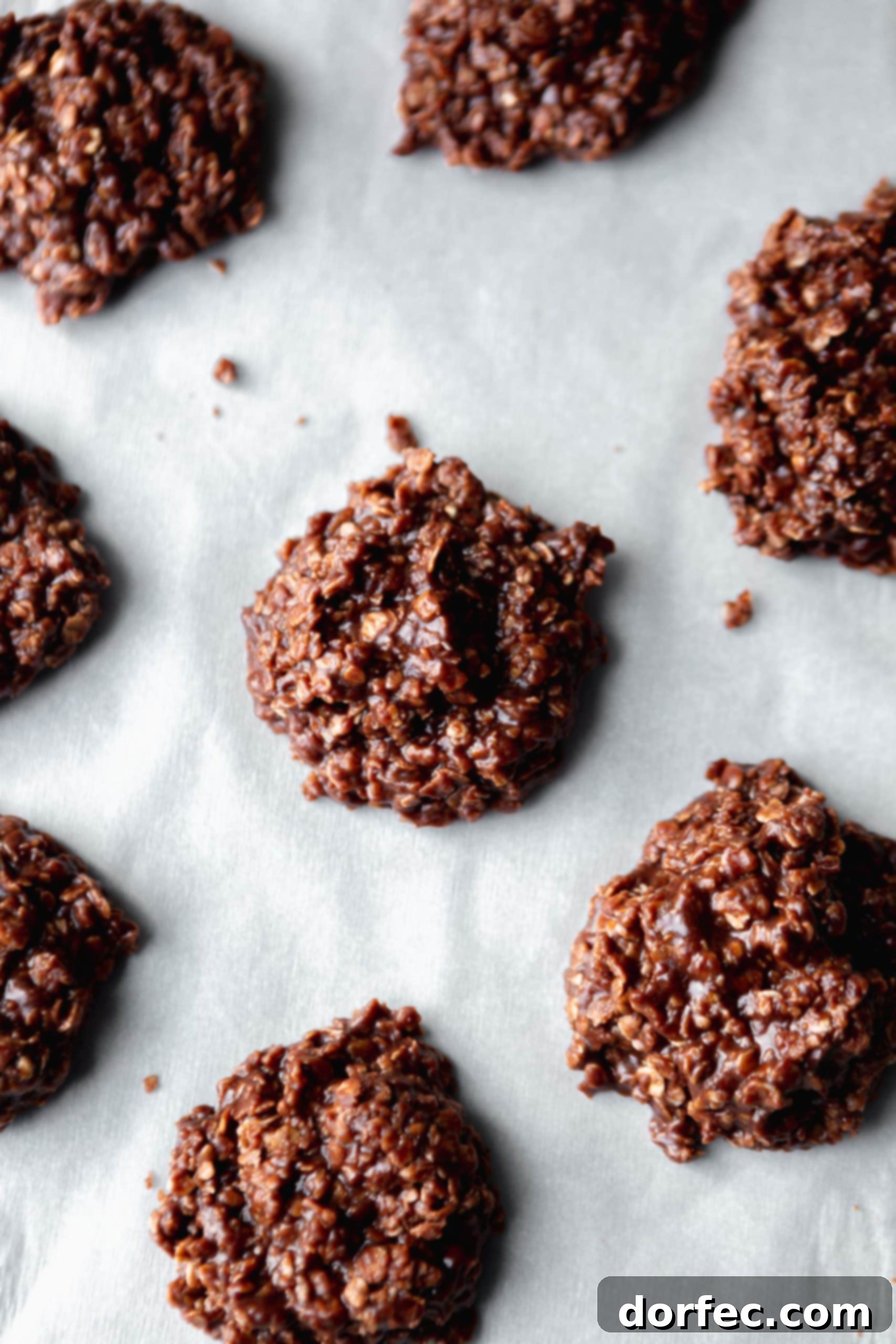Perfectly set no-bake chocolate oatmeal cookies resting on a sheet of parchment paper.