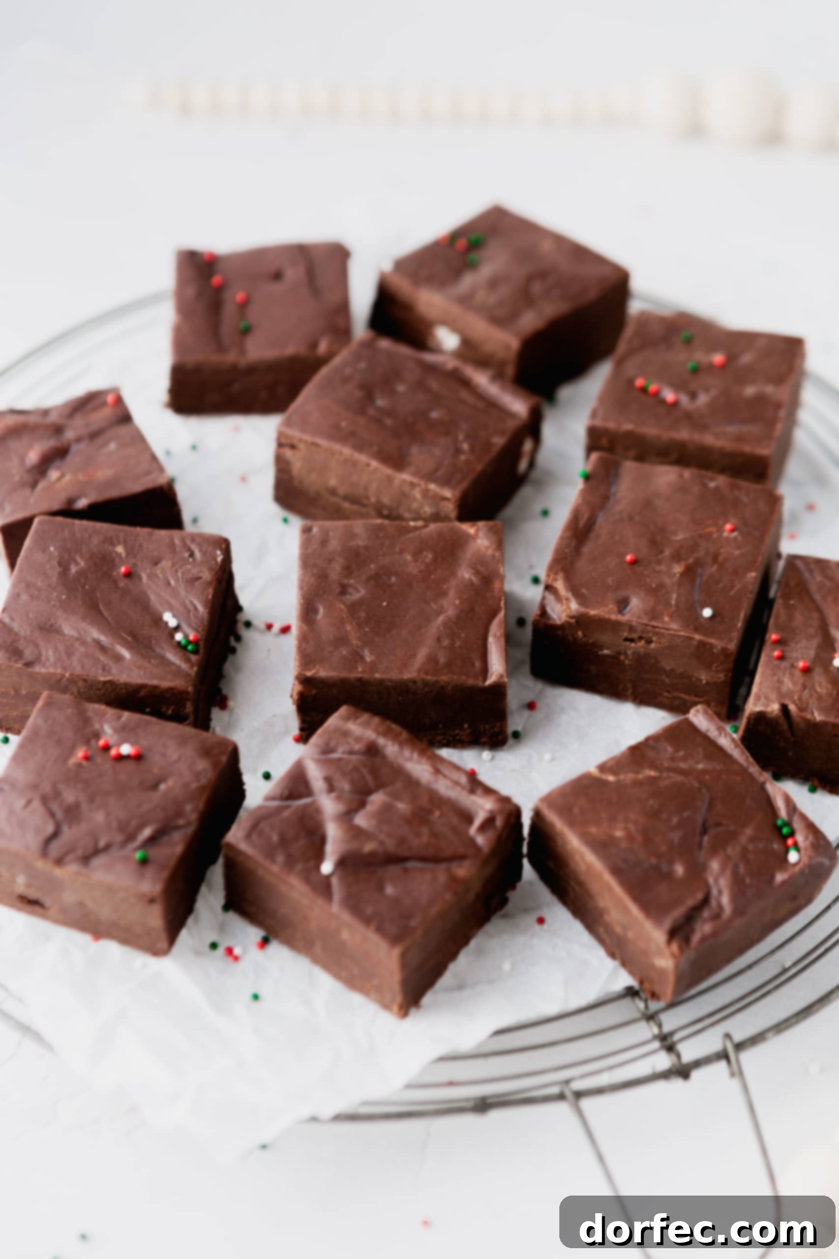A plate generously filled with perfectly square pieces of rich chocolate fudge, ready to be served.
