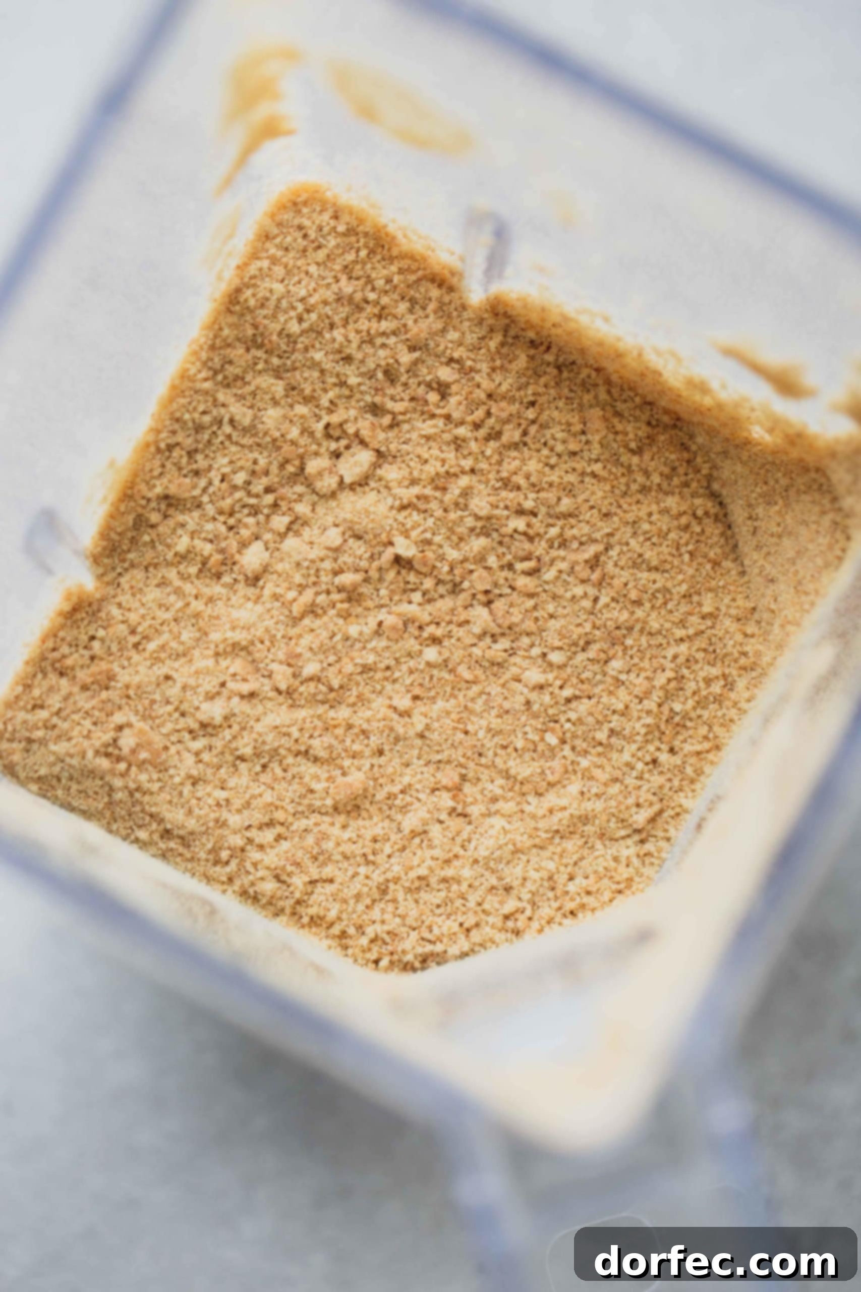 Graham Cracker Crust Fine graham cracker crumbs are shown inside a blender container, ready to be measured for a pie crust recipe.