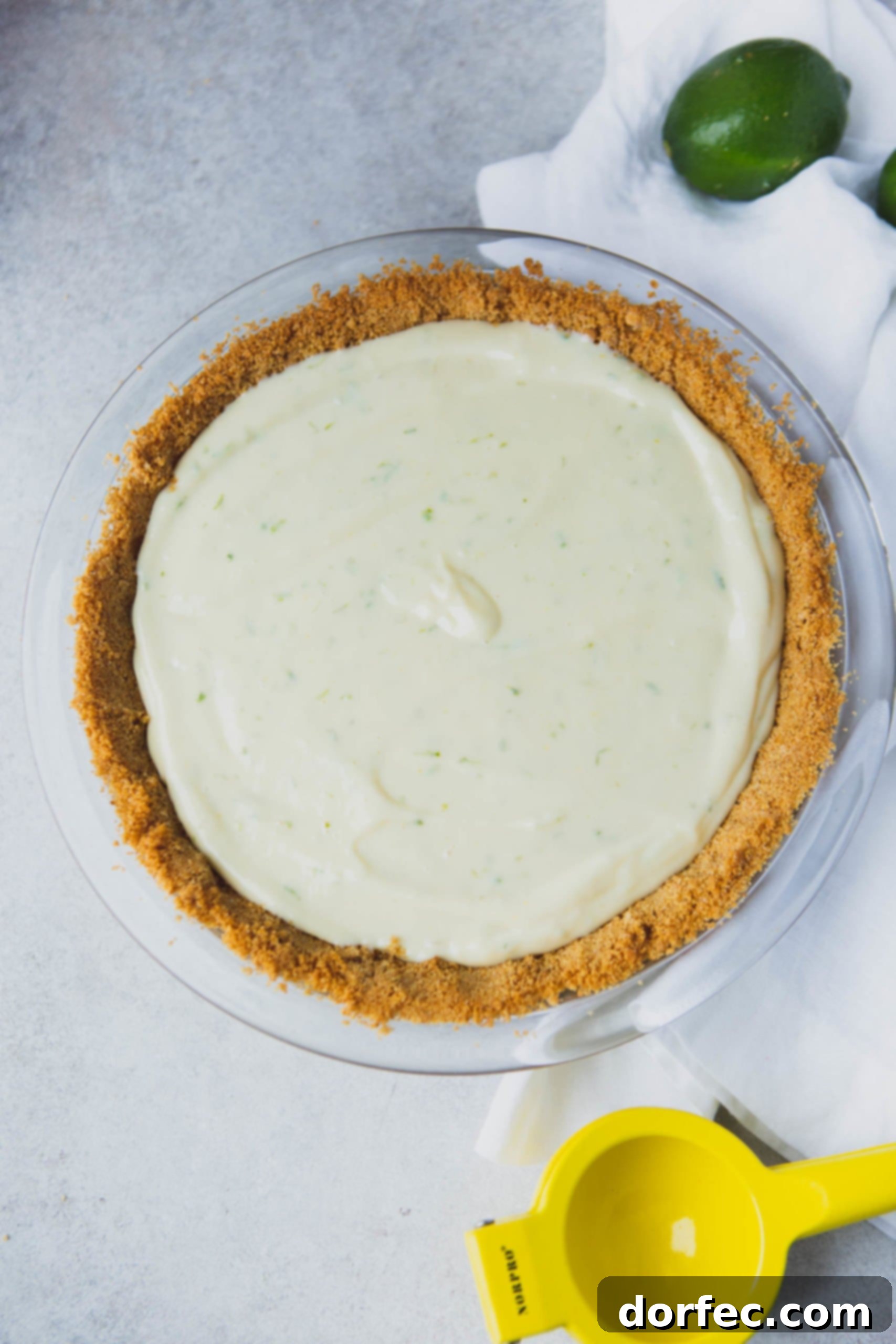 Perfectly Baked Key Lime Pie A pristine Key Lime Pie, boasting a perfectly golden graham cracker crust and a smooth, pale green filling, awaiting its final decorations.
